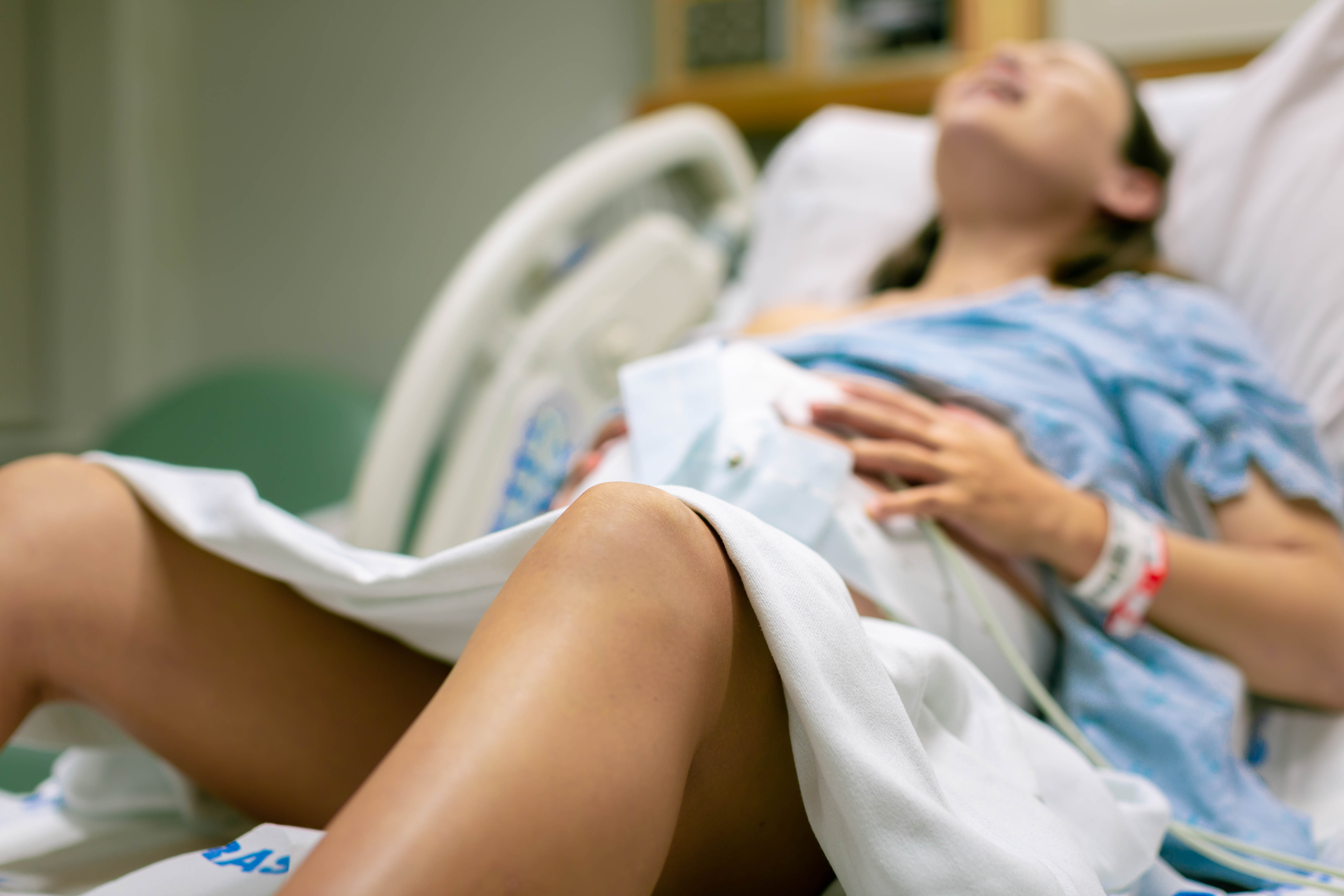 Foto de una mujer de parto tumbada en la cama del hospital. | Foto: Shutterstock