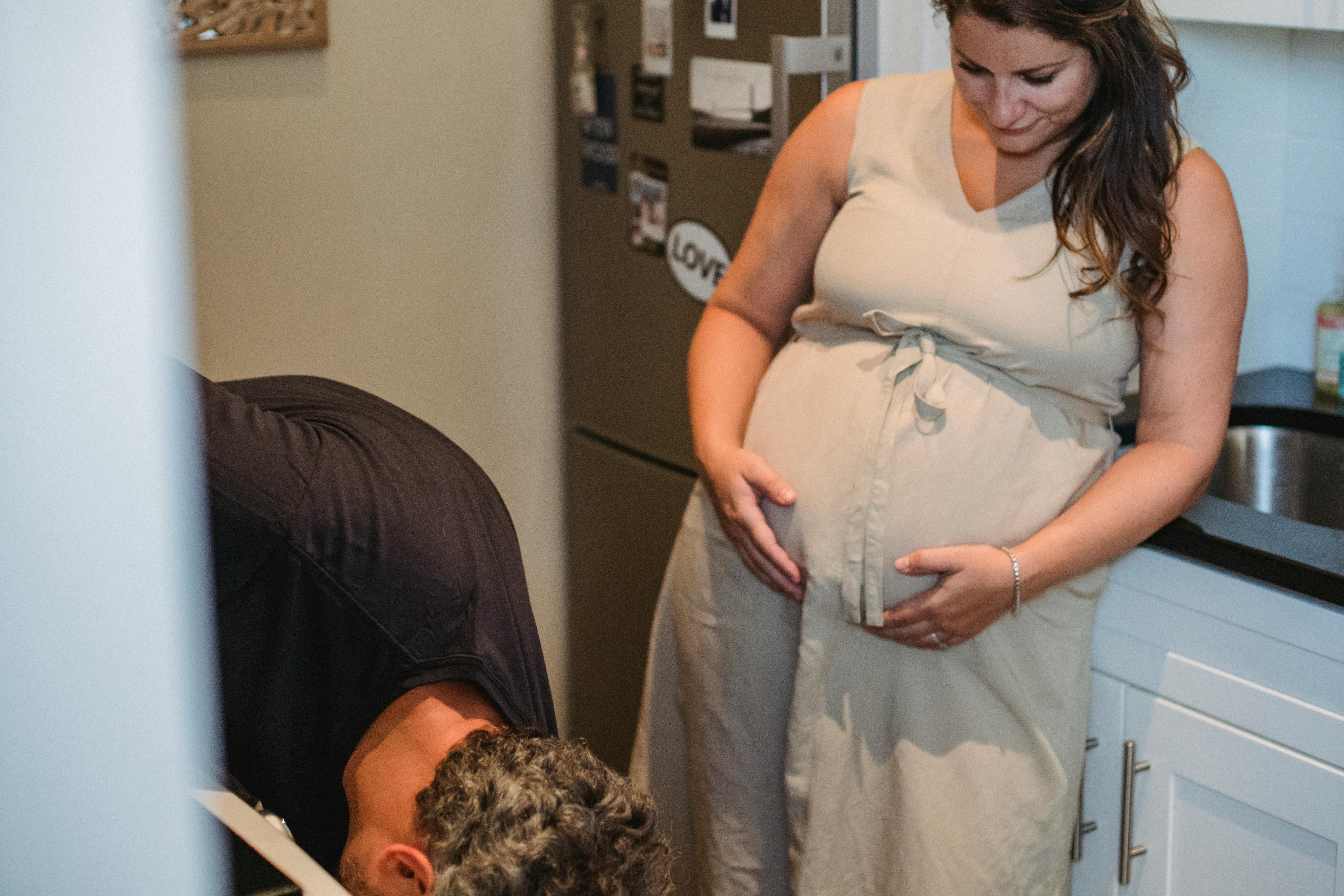 A pregnant woman touching her belly while looking at husband | Source: Pexels