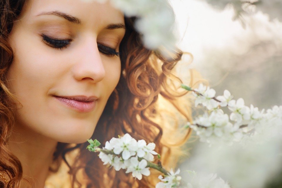Mujer mirando flor / Imagen tomada de: Pixabay
