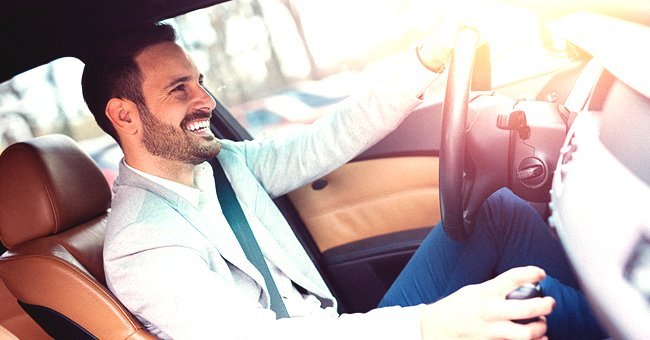 A man driving and laughing in the driver's seat | Shutterstock.com