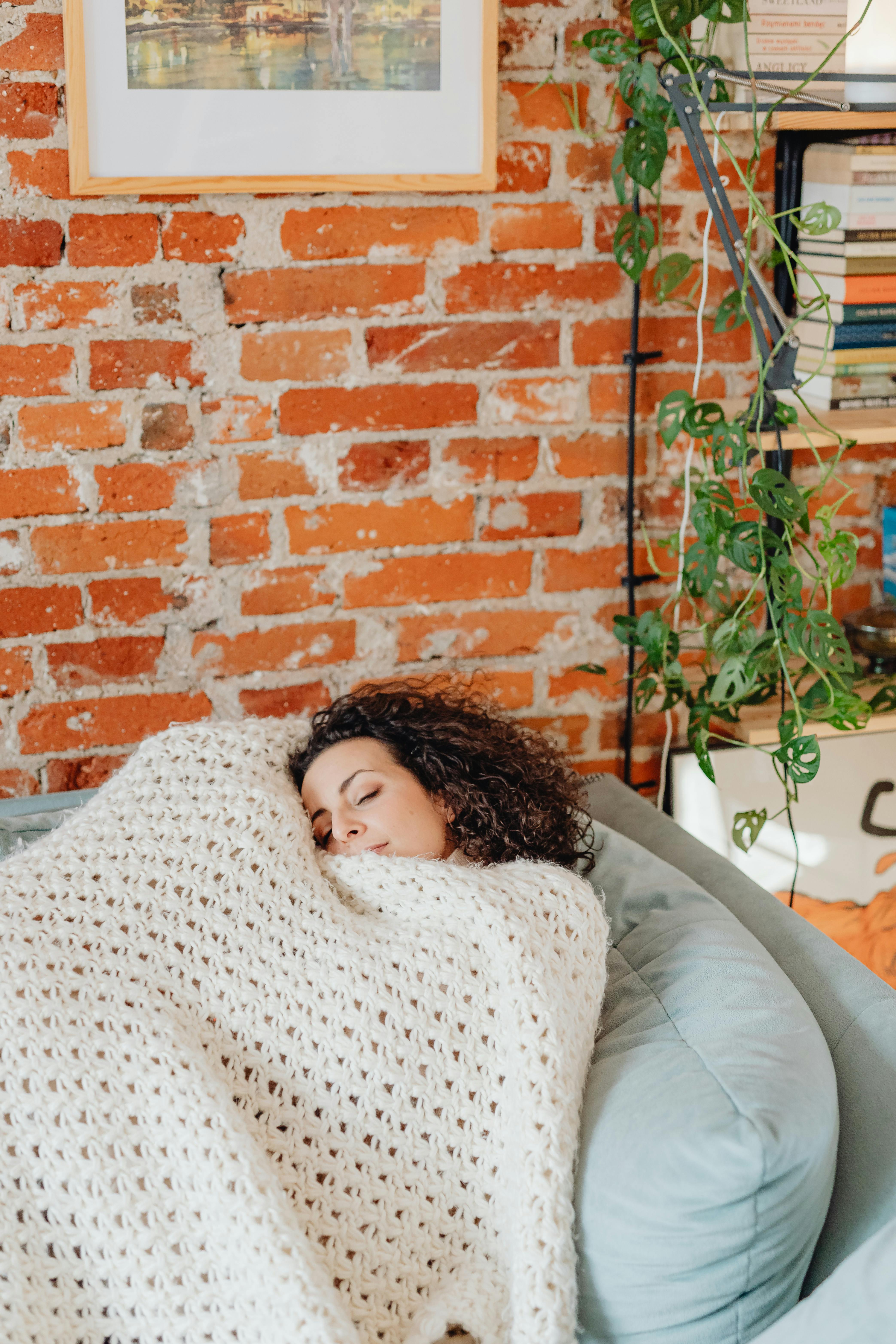 A woman covered in a light blanket while sleeping | Source: Pexels