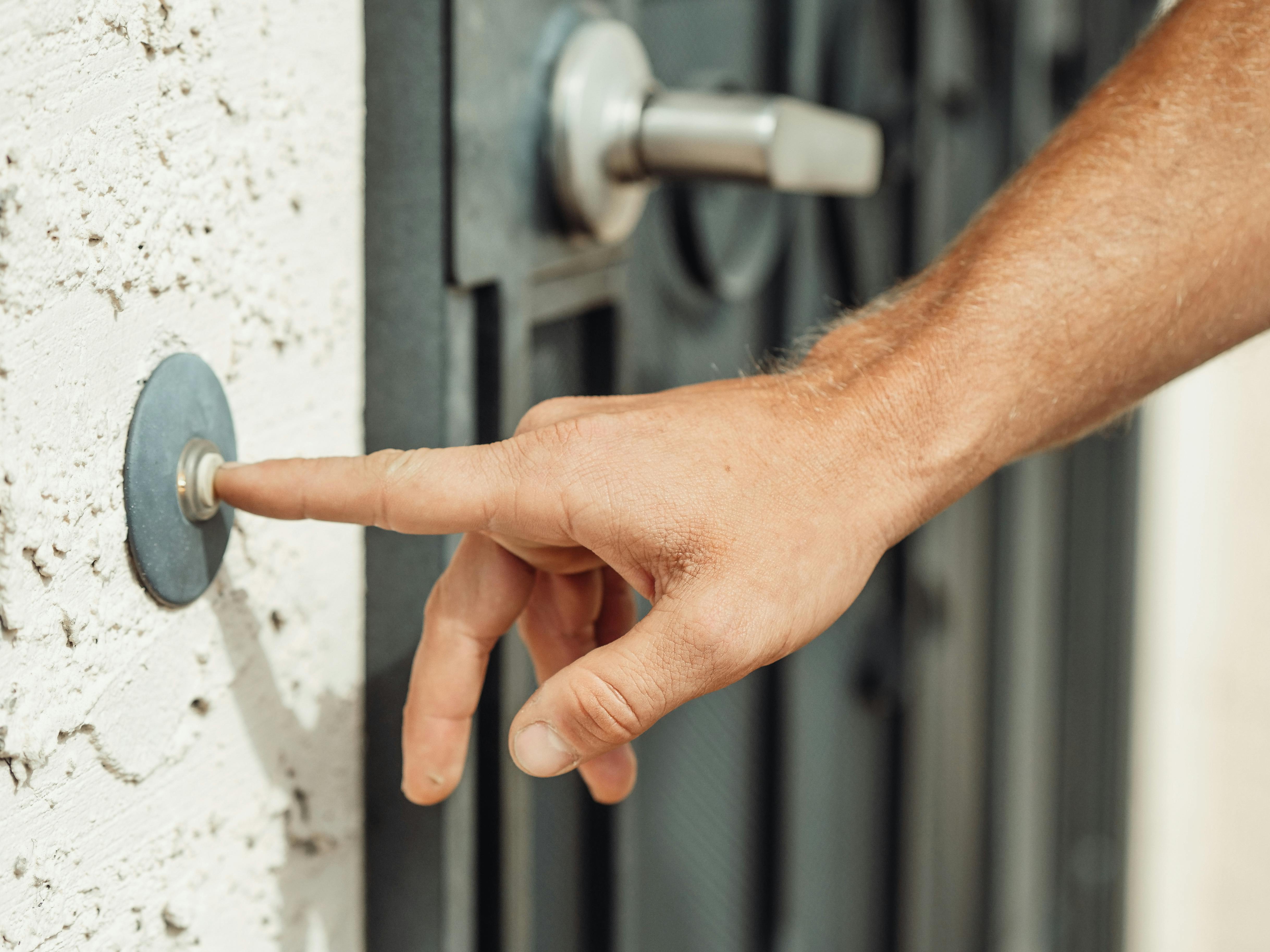 A person ringing a doorbell | Source: Pexels