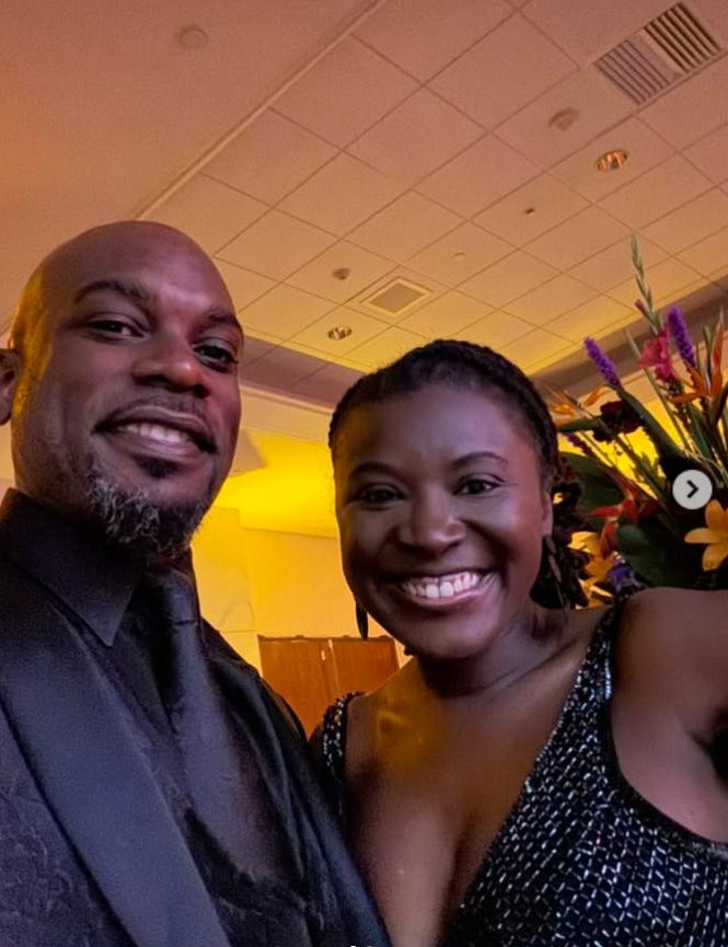 Nancy Metayer Bowen and her husband, Stephen Bowen, pose closely for a smiling selfie at an indoor event, both dressed in elegant evening attire, with warm lighting and floral arrangements visible in the background. | Source: Instagram/kingsb85