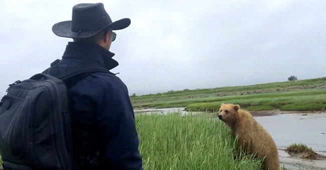 Man tries to scare bear away from him and his group | Photo: Youtube/The Bear Necessities
