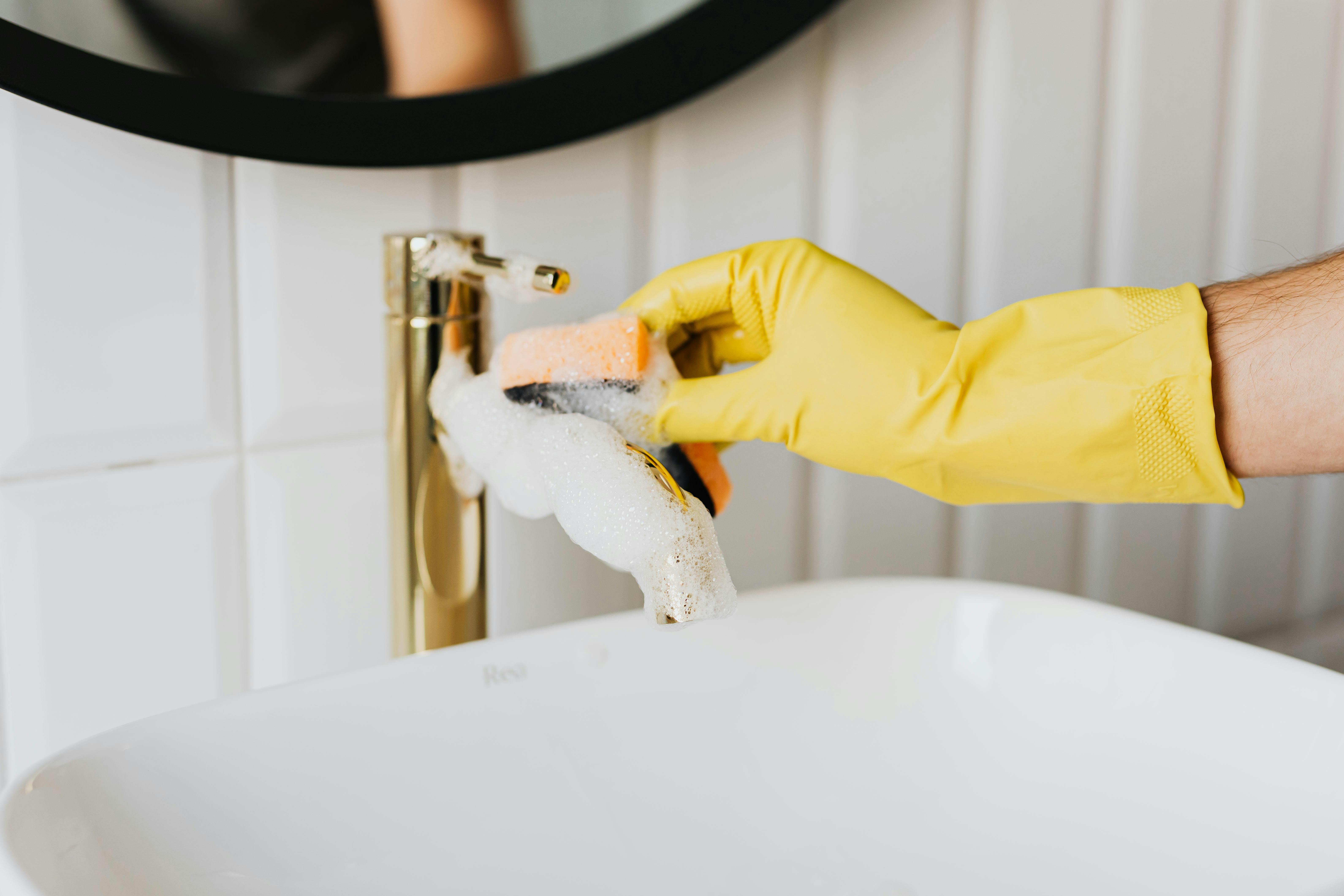 A person cleaning a bathroom sink | Source: Pexels