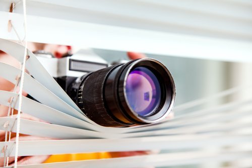 A person spying through a window. | Source: Shutterstock.