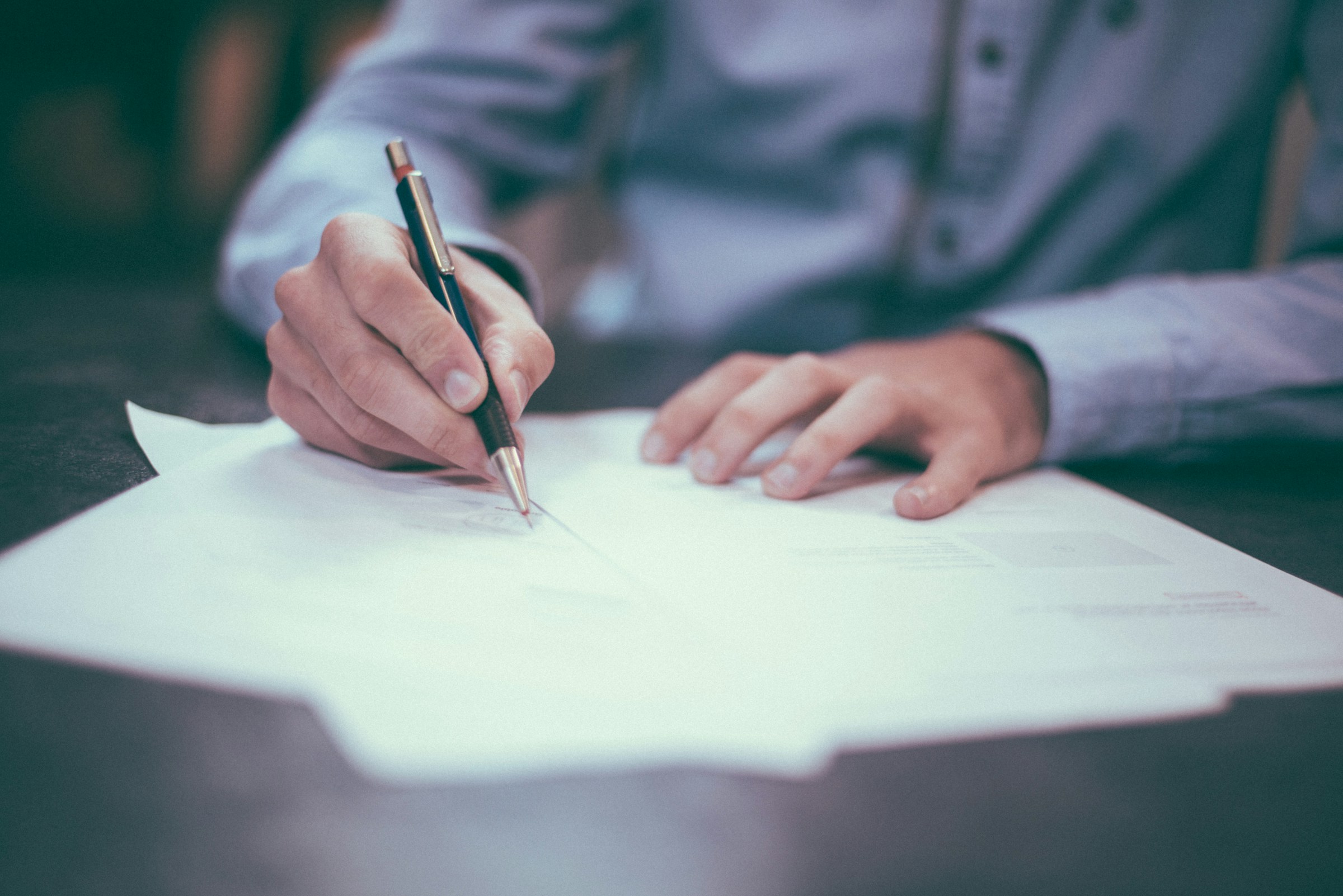 A person signing a document | Source: Unsplash
