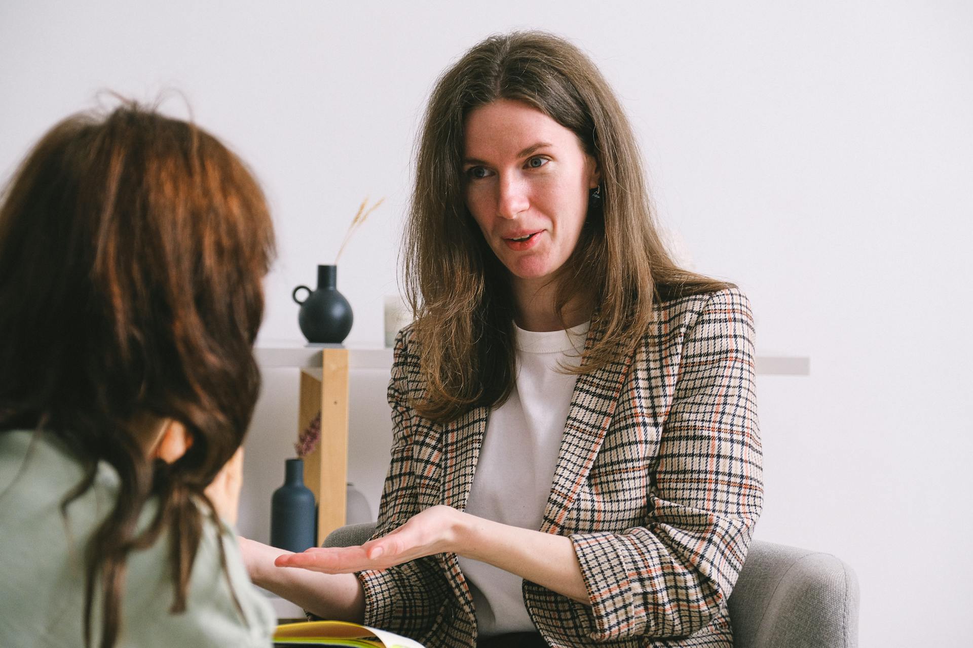 A smiling female therapist talking to a female patient in her office | Source: Pexels