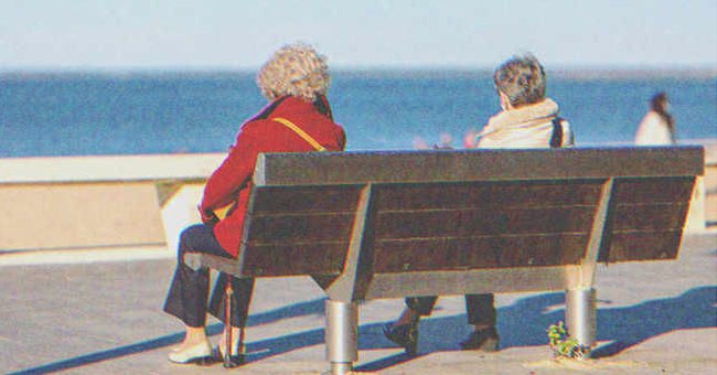 Two woman sitting on a bench by the beach | Source: Shutterstock