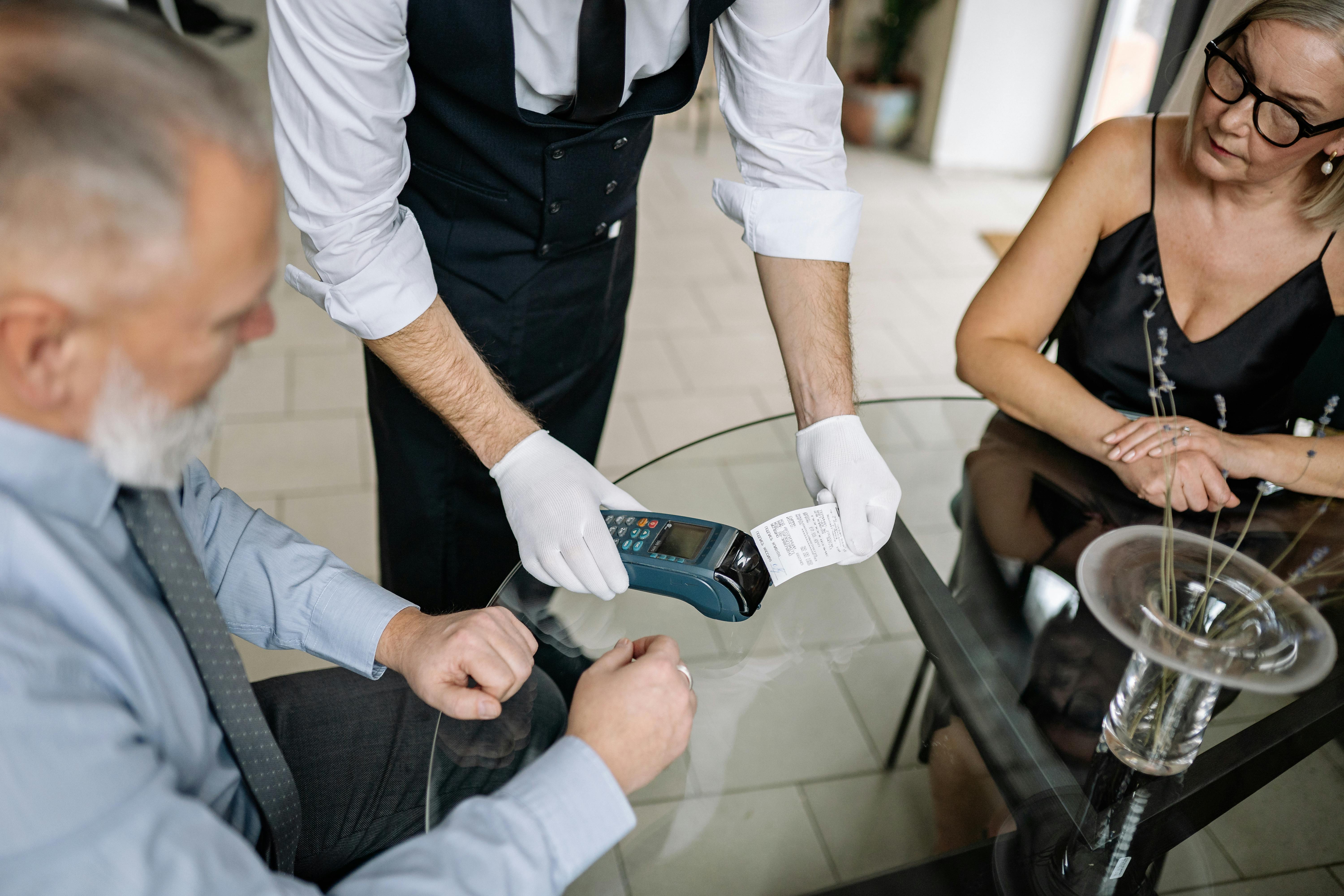 Two patrons trying to pay at a restaurant | Source: Pexels