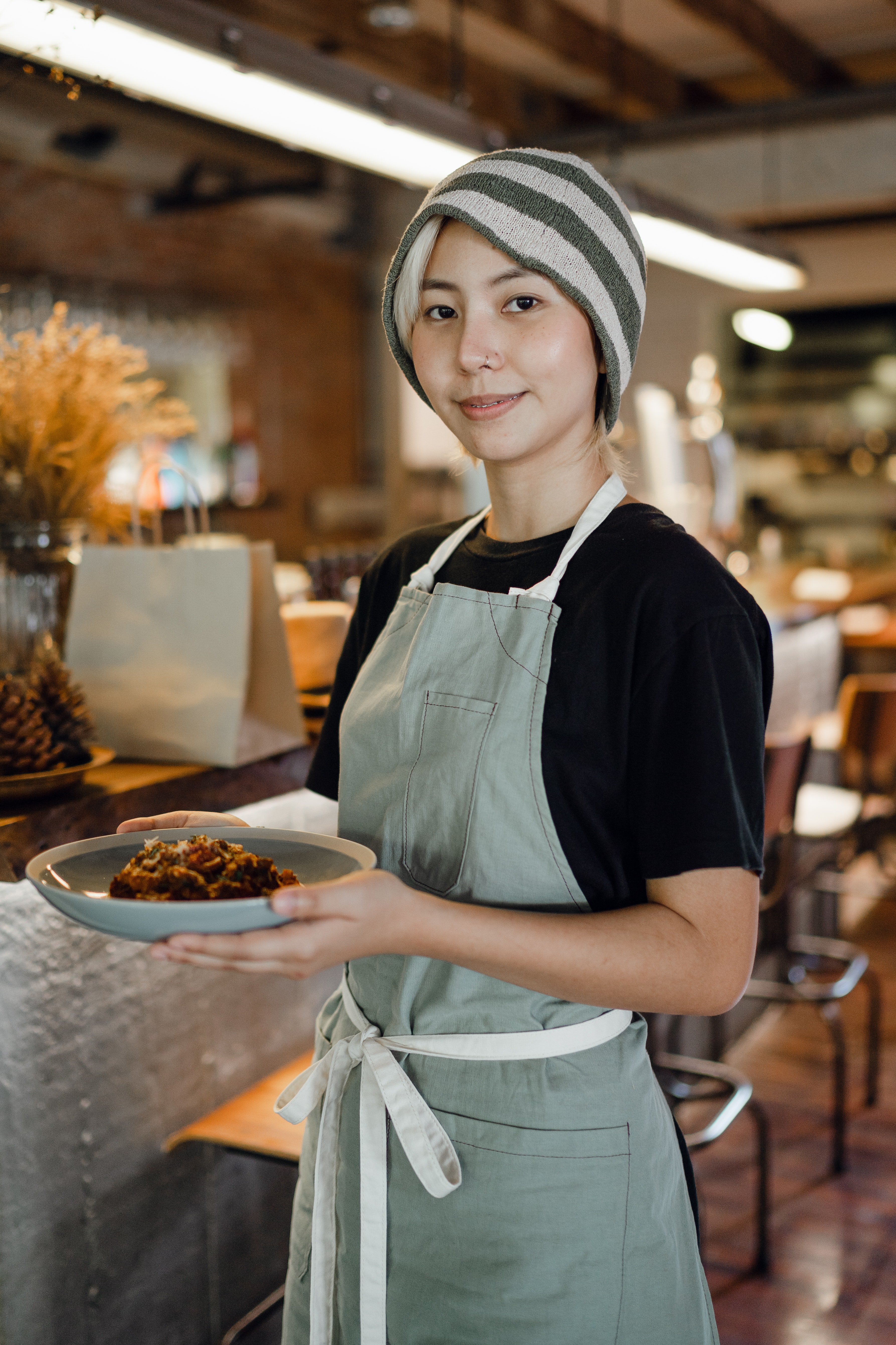  A woman carrying a plate of food in a restaurant. | Photo: Pexels/Ketut Subiyanto
