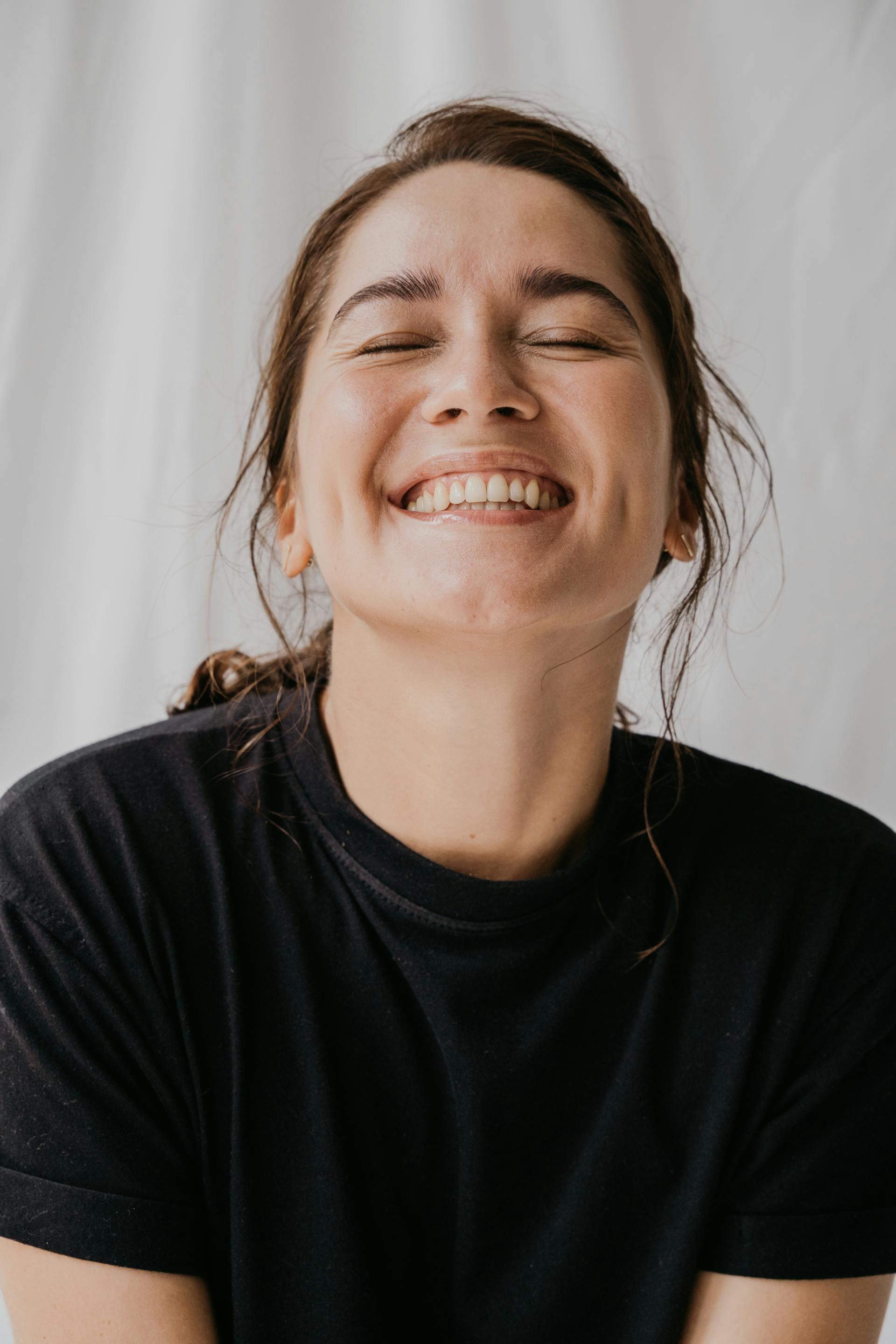 A woman smiling with her eyes closed | Source: Pexels
