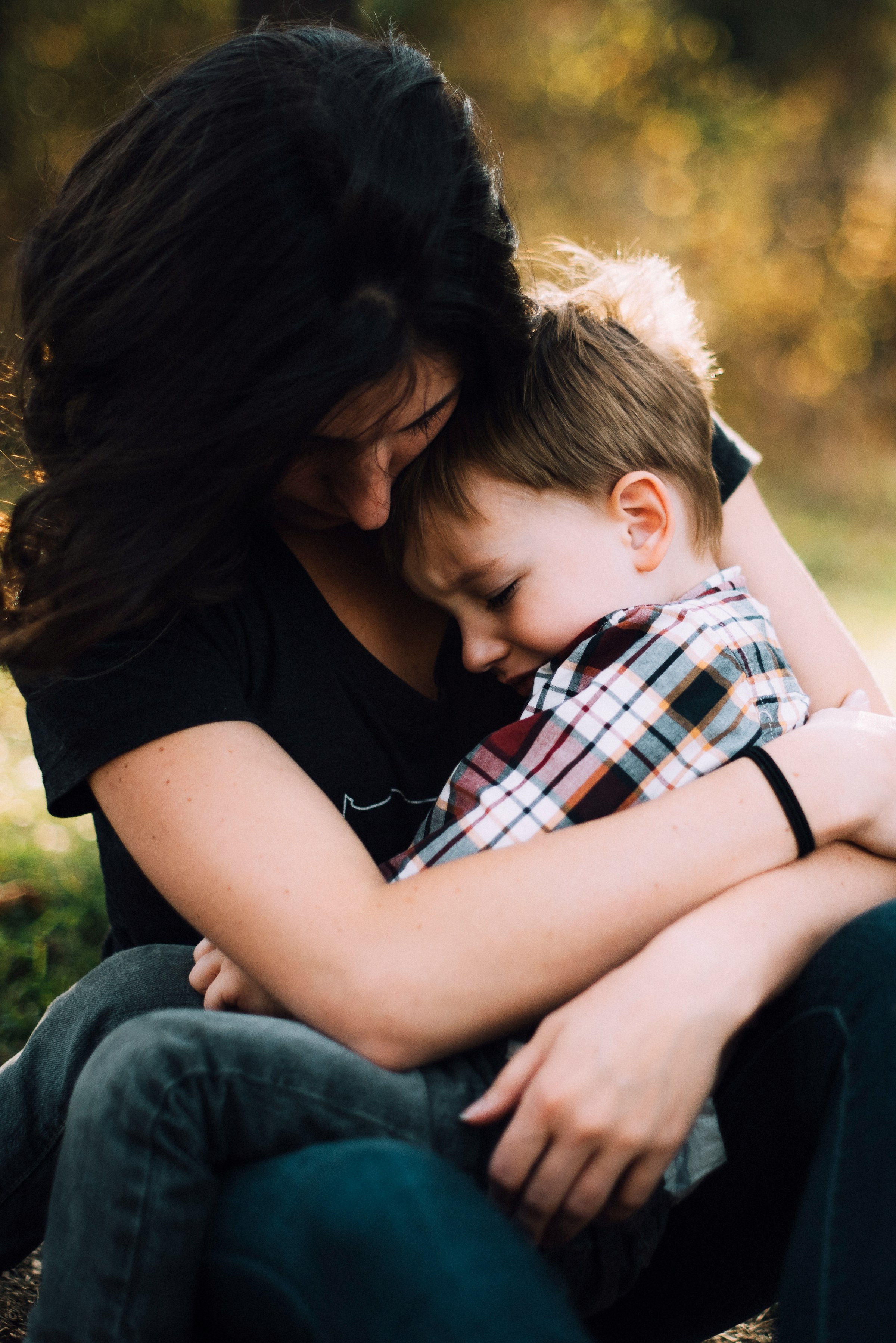 A woman hugging a crying little boy | Source: Unsplash