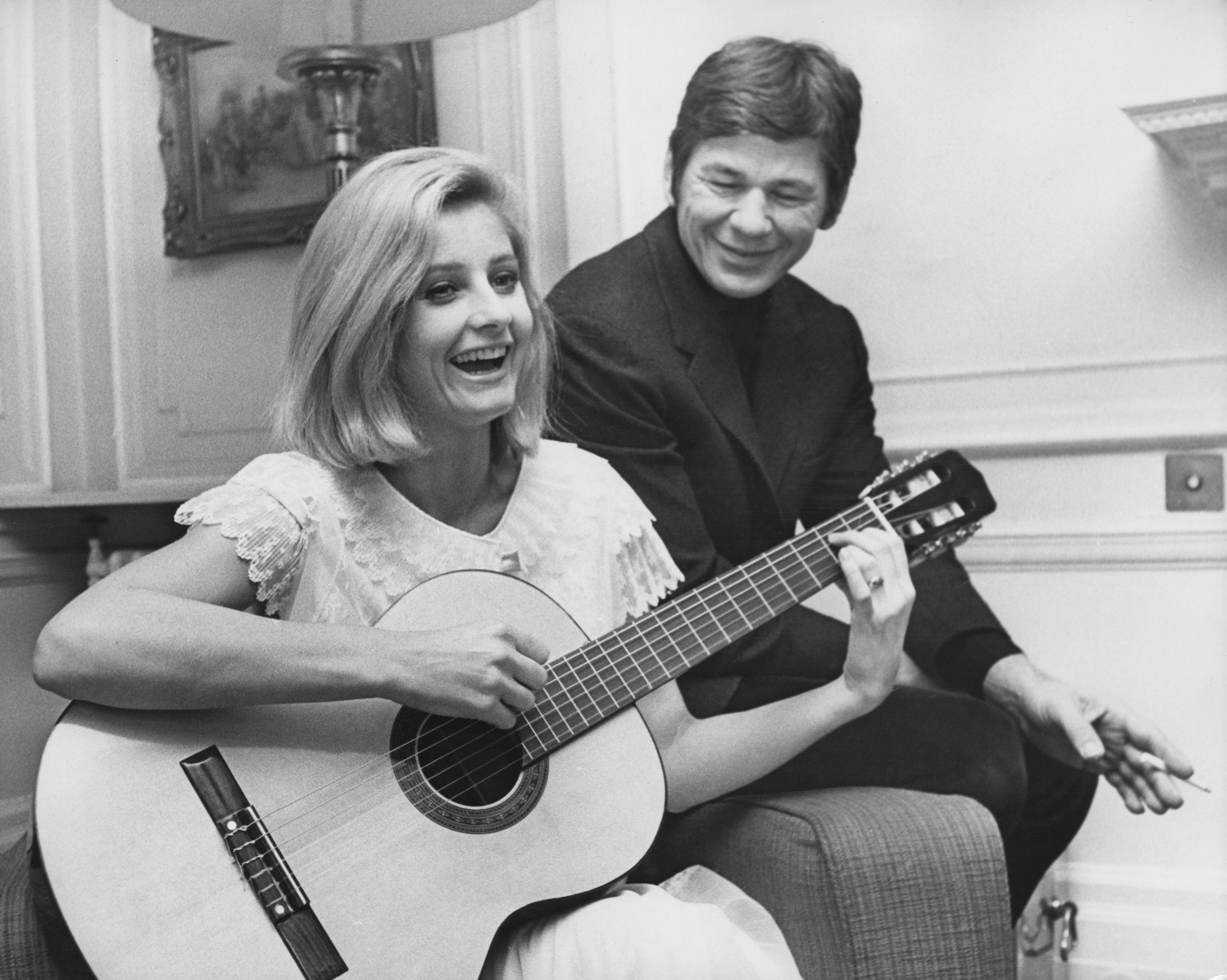 Actor Charles Bronson listens to his wife, actress Jill Ireland play the guitar in London, 9th January 1969. | Source: Getty Images