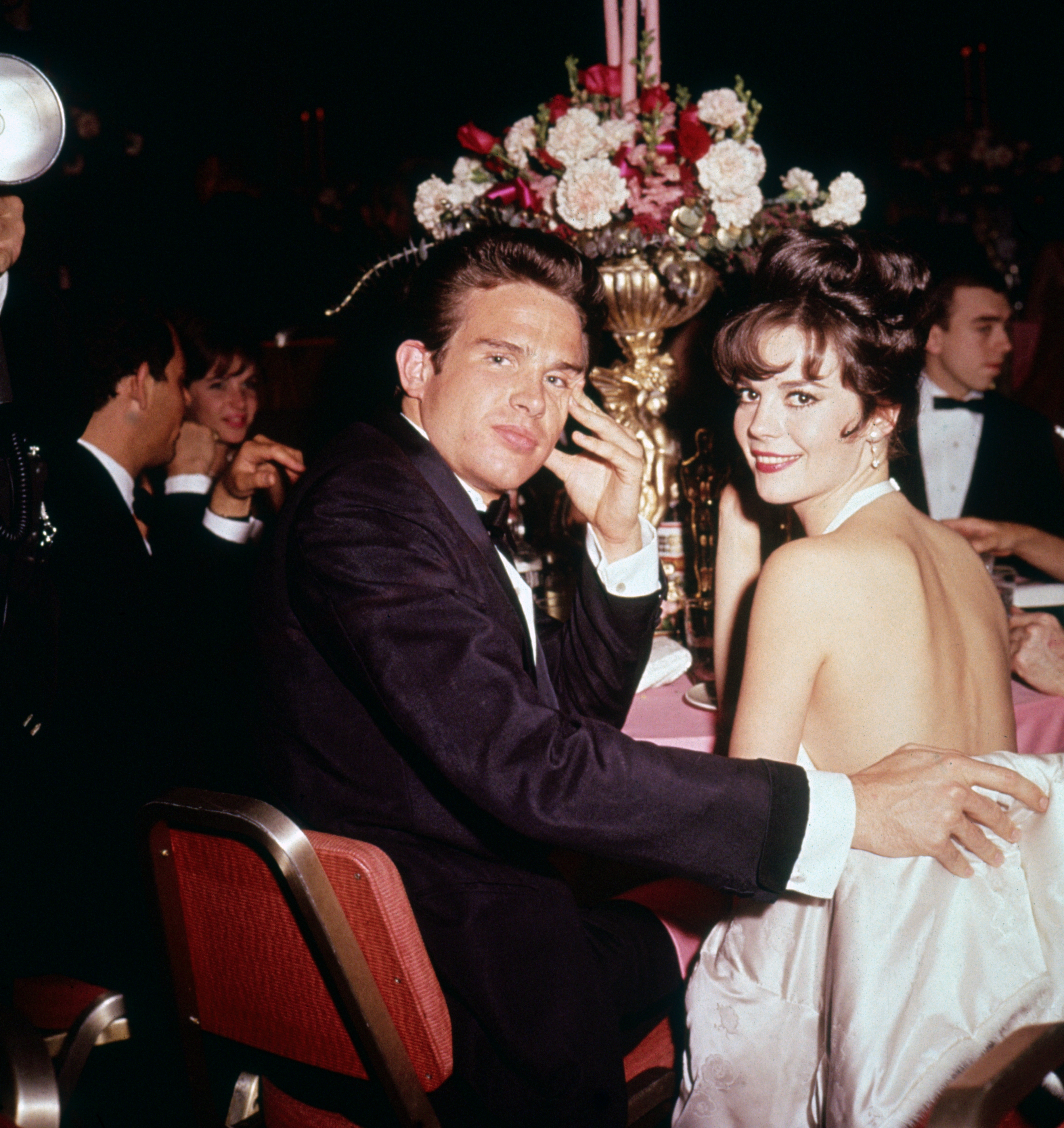 Warren Beatty and actress Natalie Wood pictured while seated together at a formal event on January 1, 1961 | Source: Getty Images