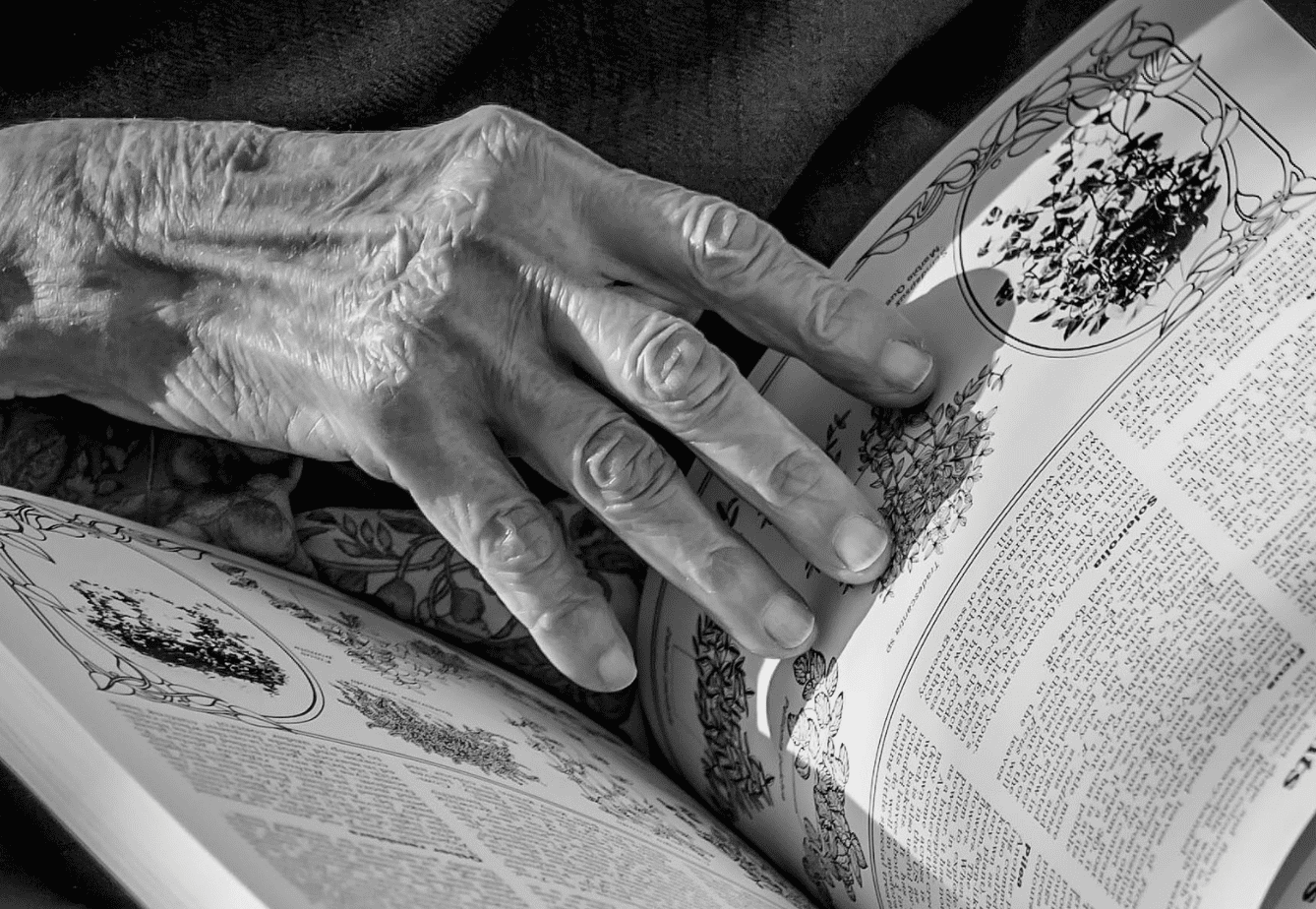 Old woman paging through a book. | Source: flickr.com