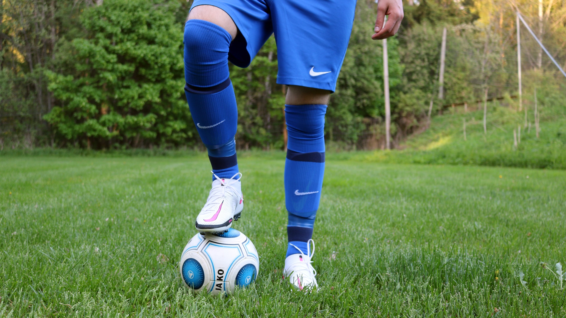 A person holding a soccer ball under his foot | Source: Pexels