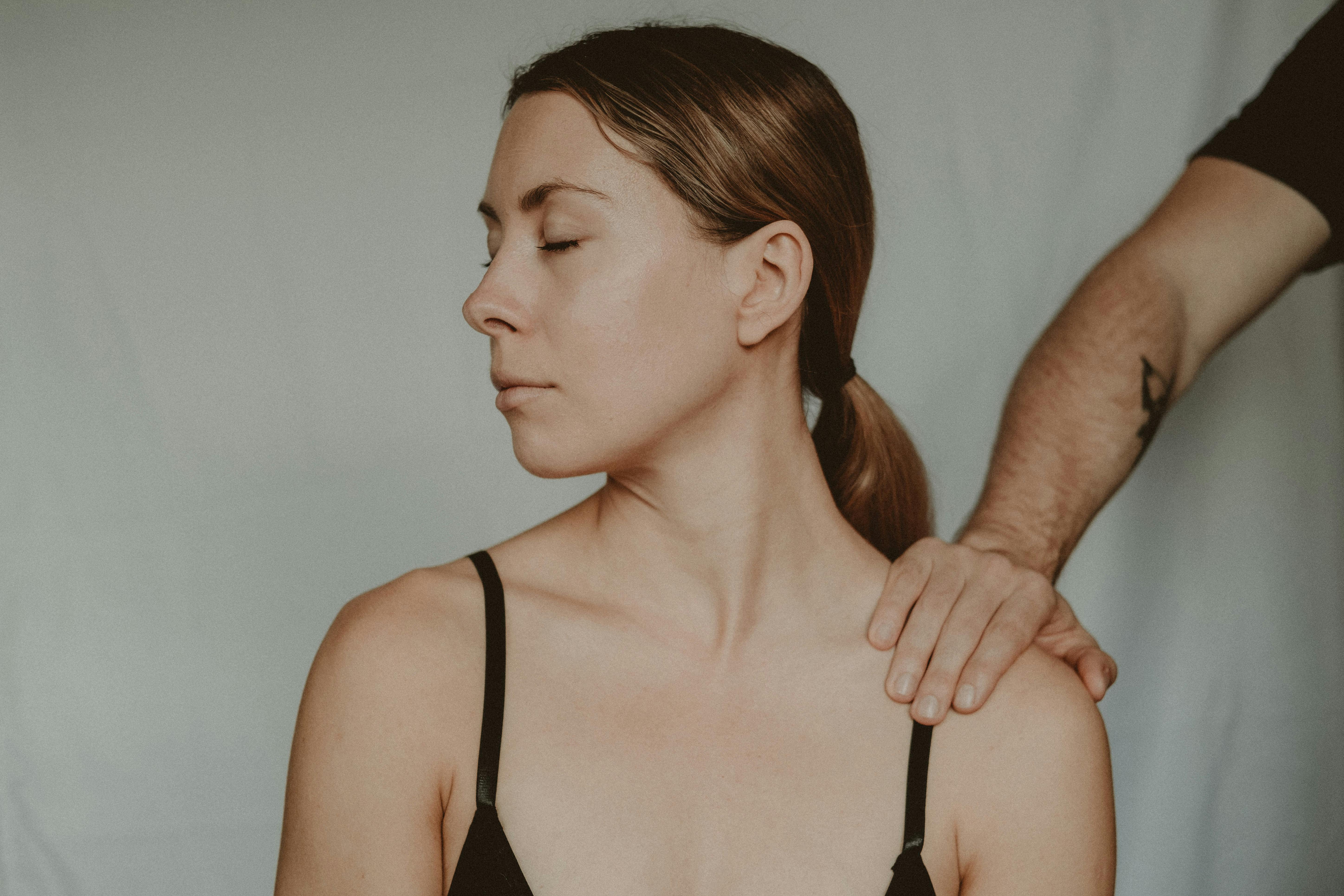 A man's hand on an upset woman's shoulder | Source: Pexels