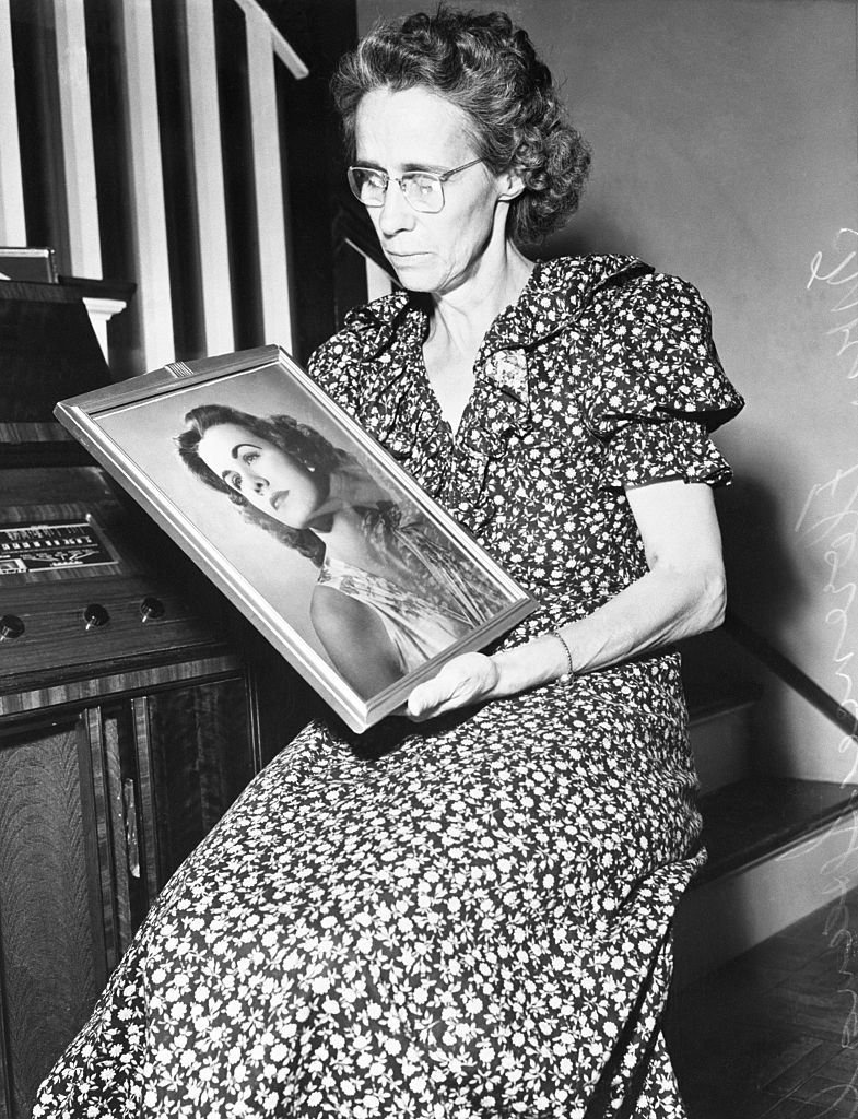 Florence, la mère de Jean, écoutant la radio tout en regardant une photo de sa fille disparue, 1949 | Photo : Getty Images