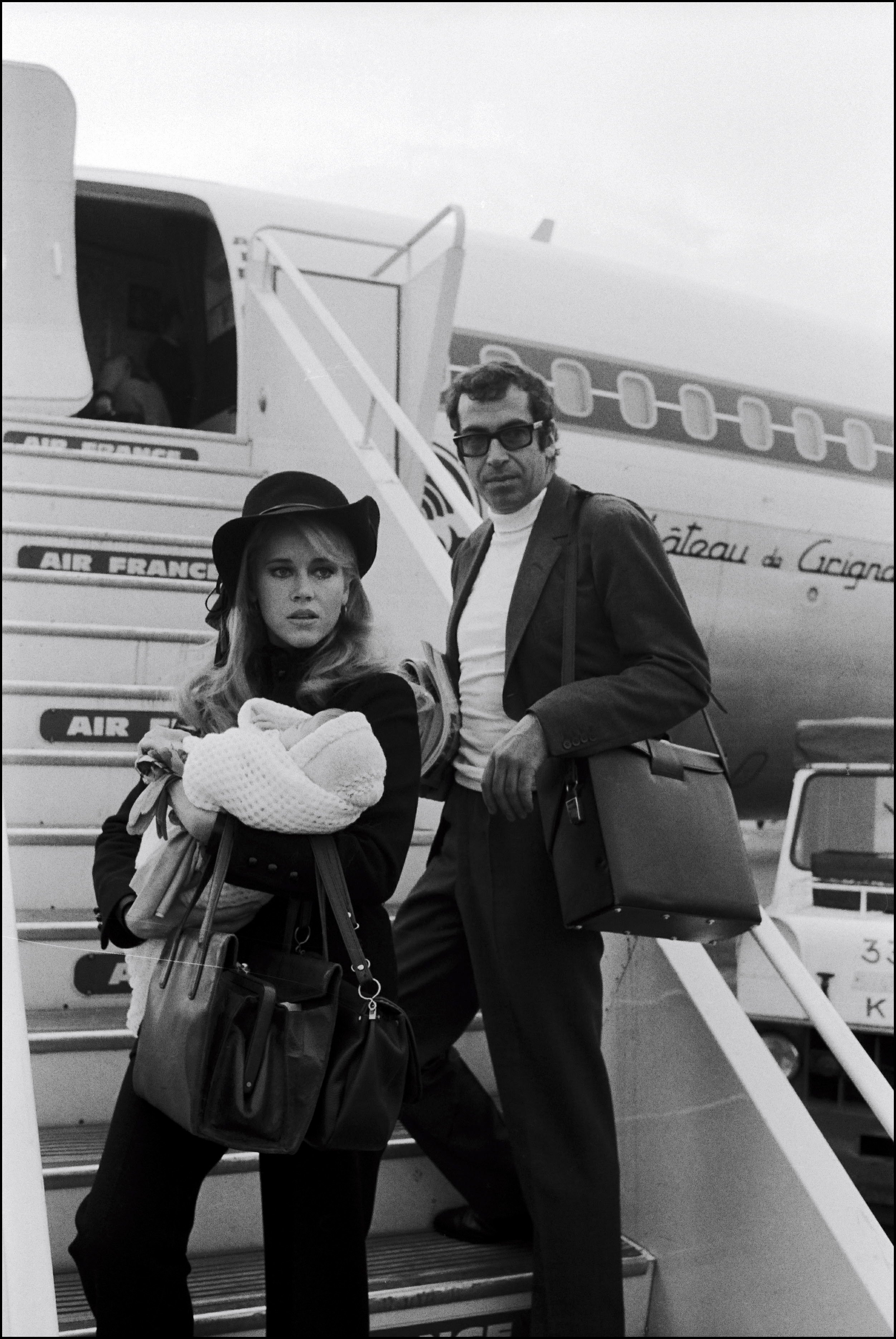 Jane Fonda carries daughter Vanessa Vadim beside Roger Vadim by the steps of a private plane in 1968 in France. | Photo: Getty Images