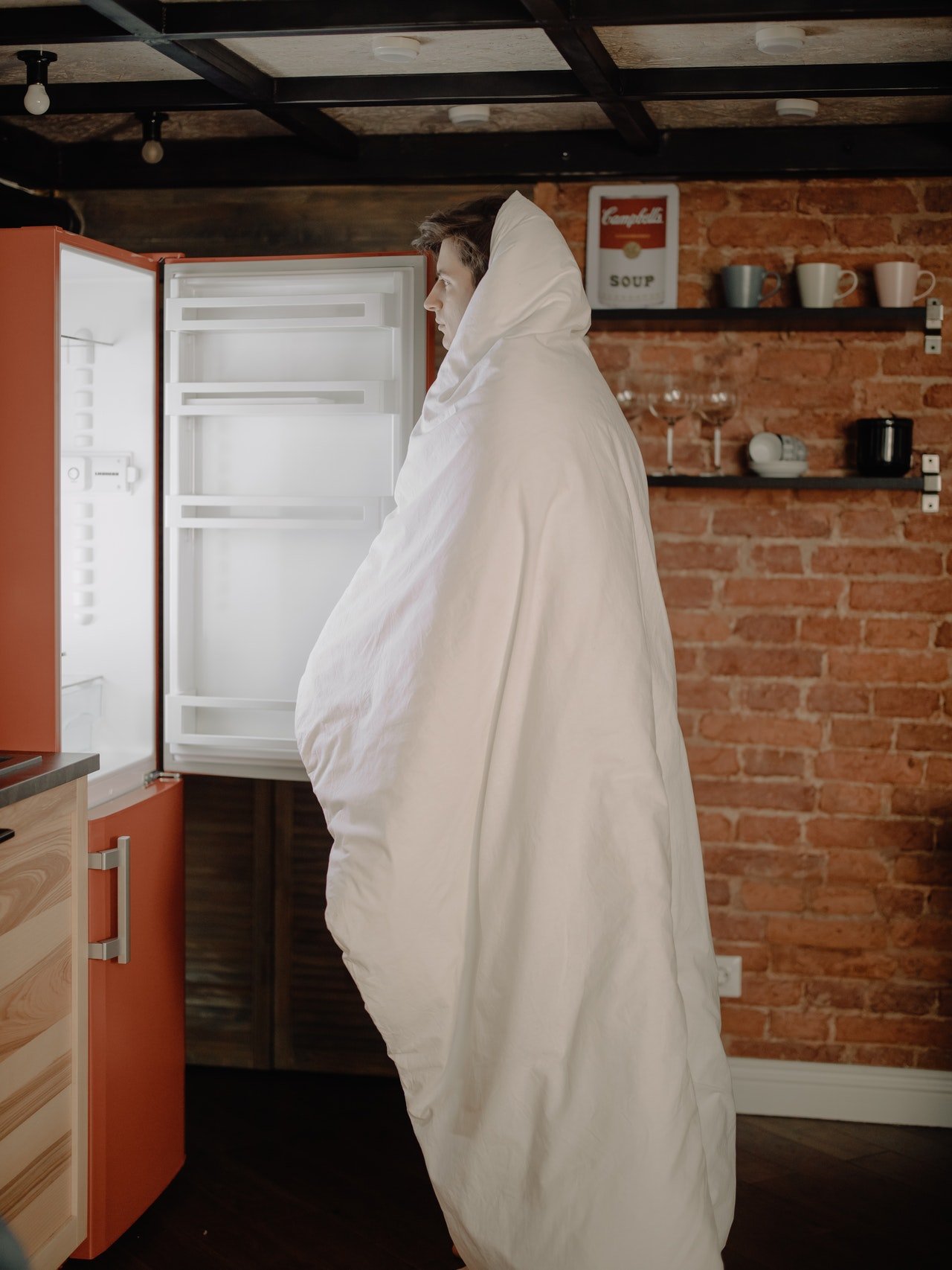 Photo of a man standing in front of an open refrigerator | Photo: Pexels