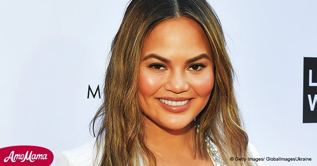 Chrissy Teigen, 32, shows off her growing baby bump while rocking a skin-tight white dress