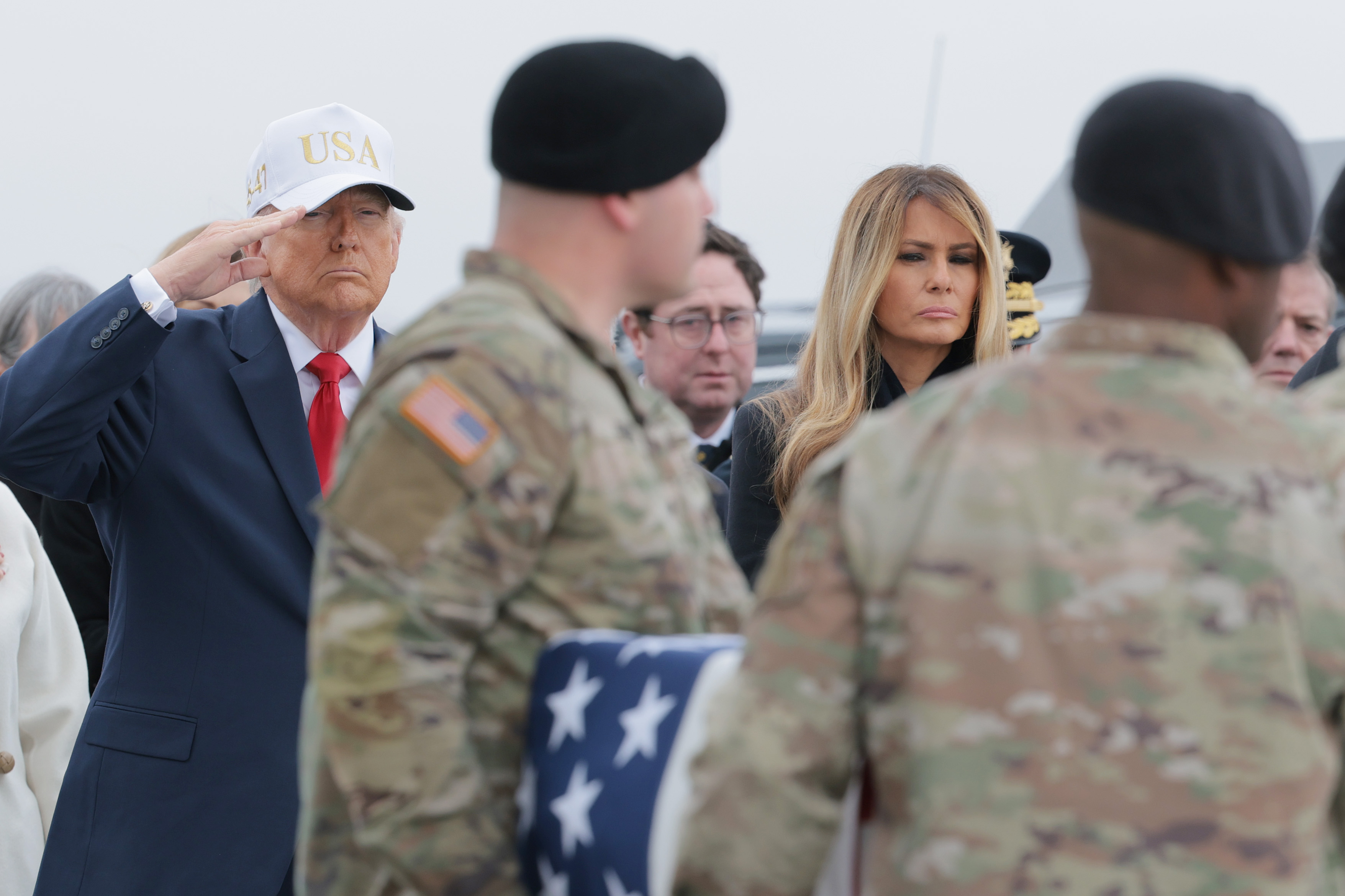 U.S. President Donald Trump and First Lady Melania Trump stand at attention as a U.S. Army carry team moves a flag-draped transfer case containing the remains of Sgt. 1st Class Noah L. Tietjens at Dover Air Force Base March 7, 2026 in Dover, Delaware | Source: Getty Images
