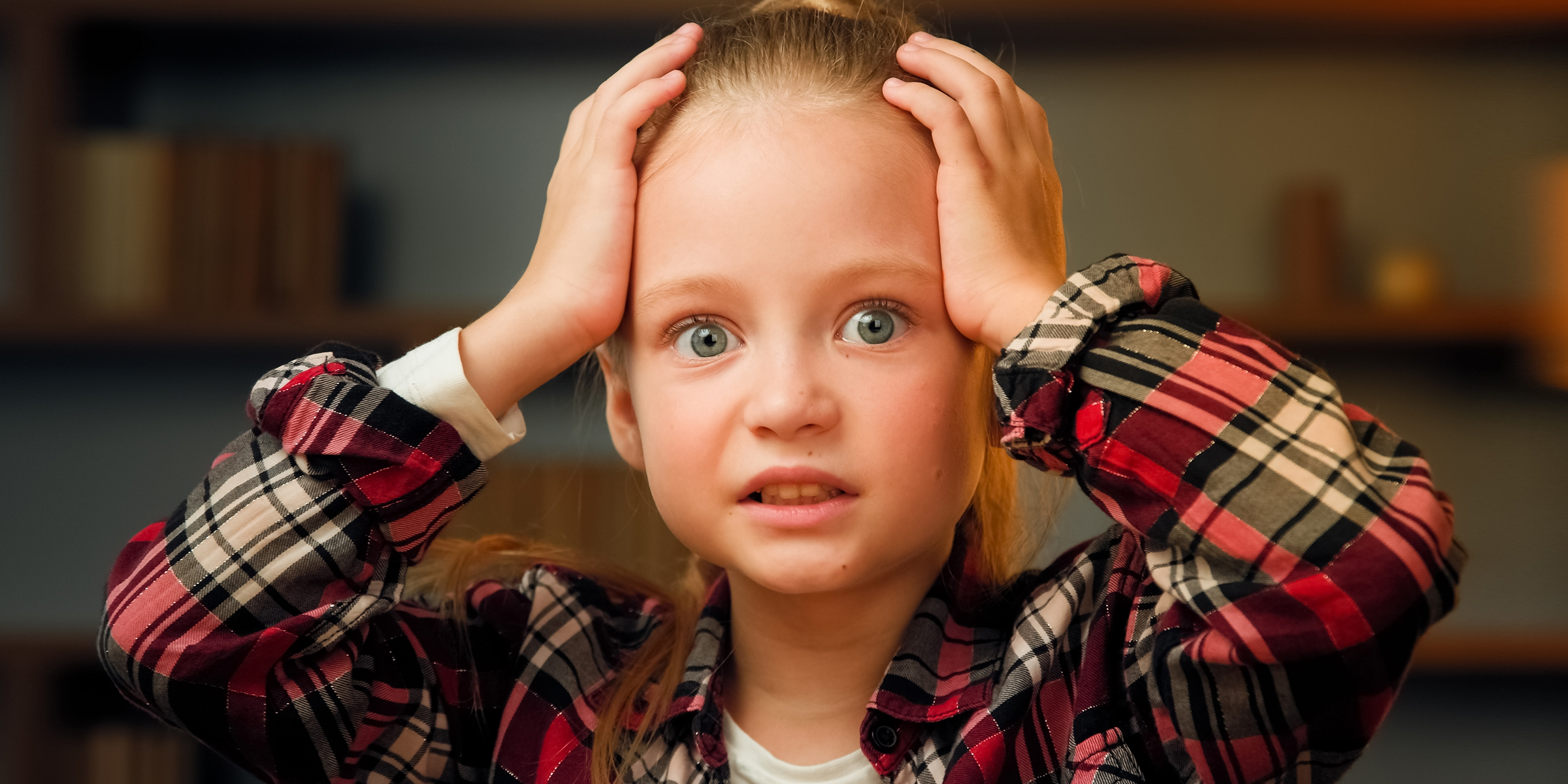 A little girl holding her head | Source: Shutterstock