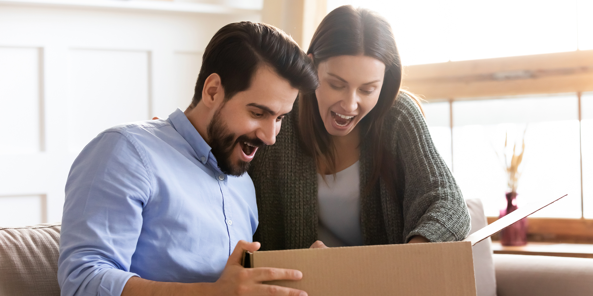 A surprised couple looking at something in a box | Source: Shutterstock