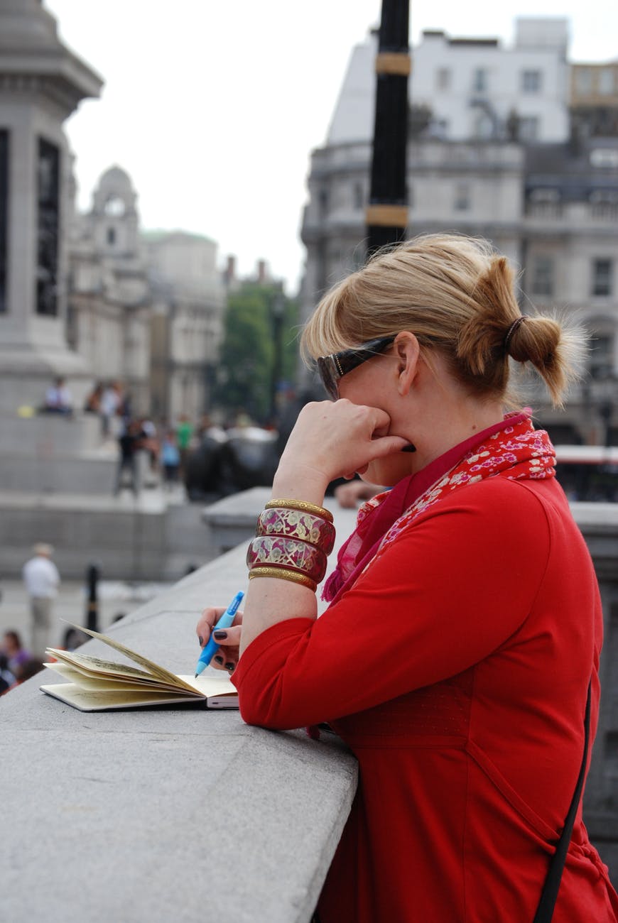 Mujer, de paseo, escribe en su libreta. | Foto: Pexels