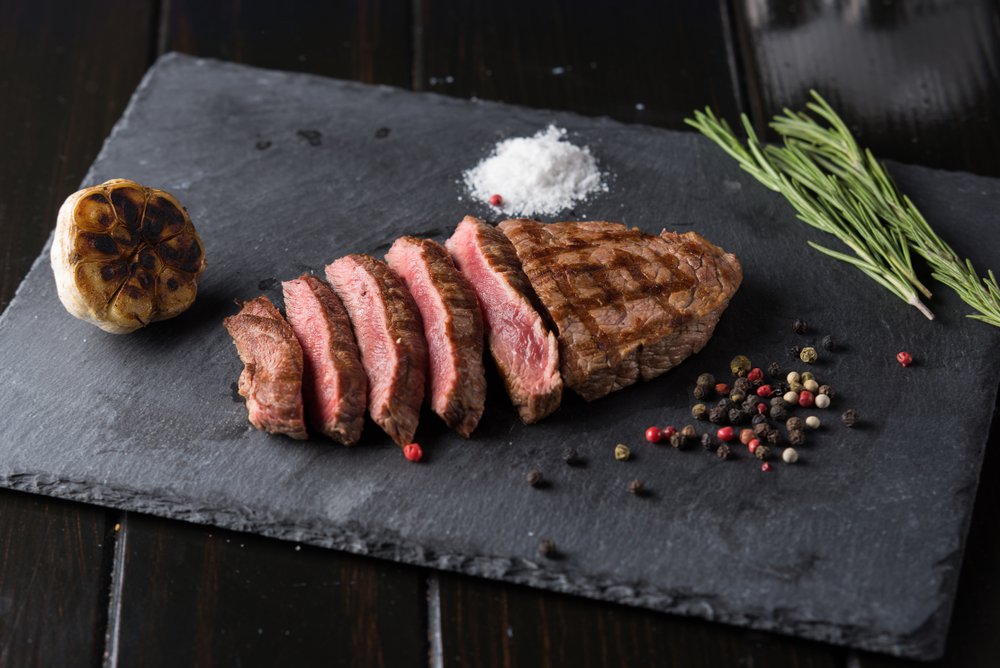 L'assaisonnement de la viande avant la cuisson | Source : Shutterstock