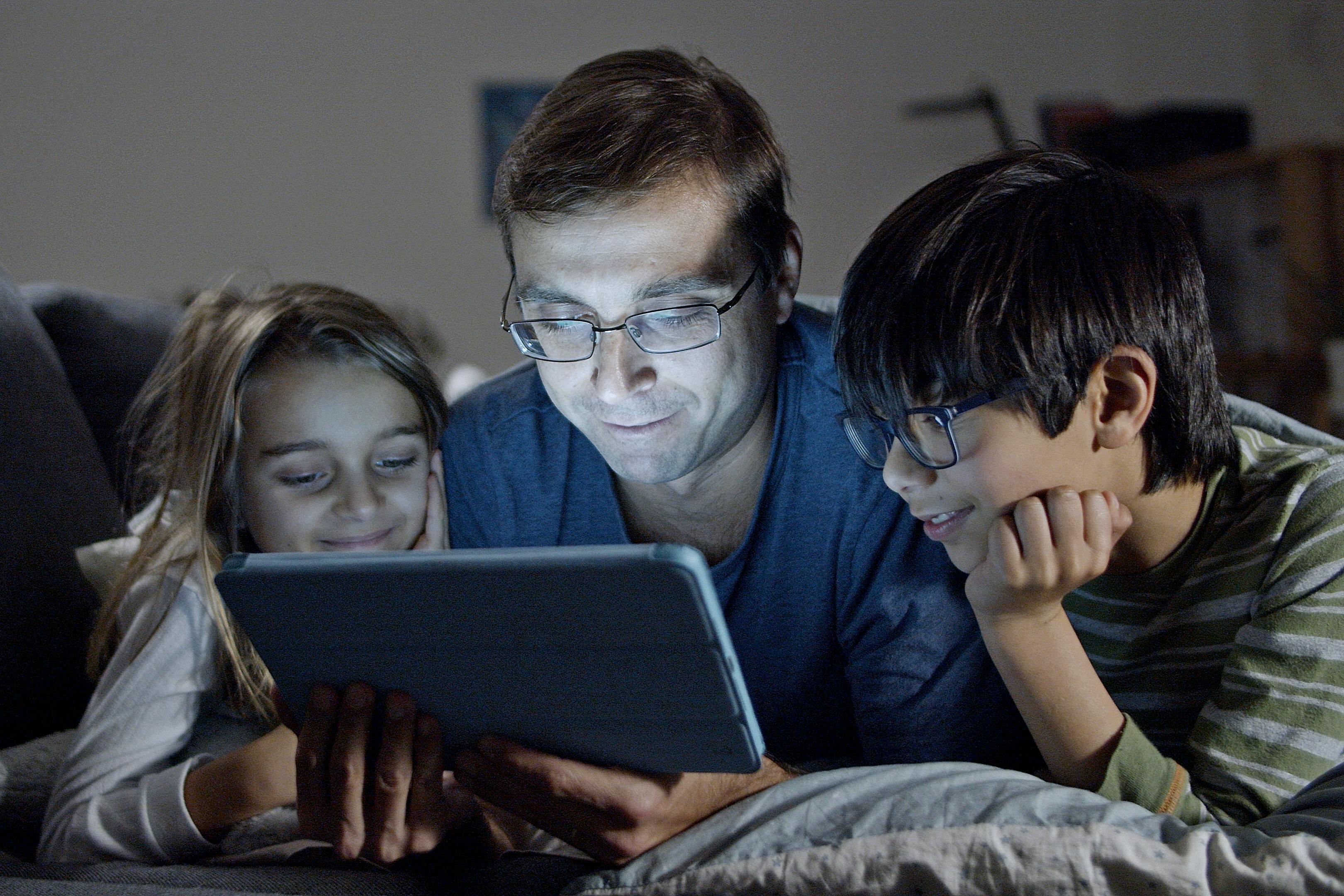 A man and his children looking at a tablet | Source: Pexels