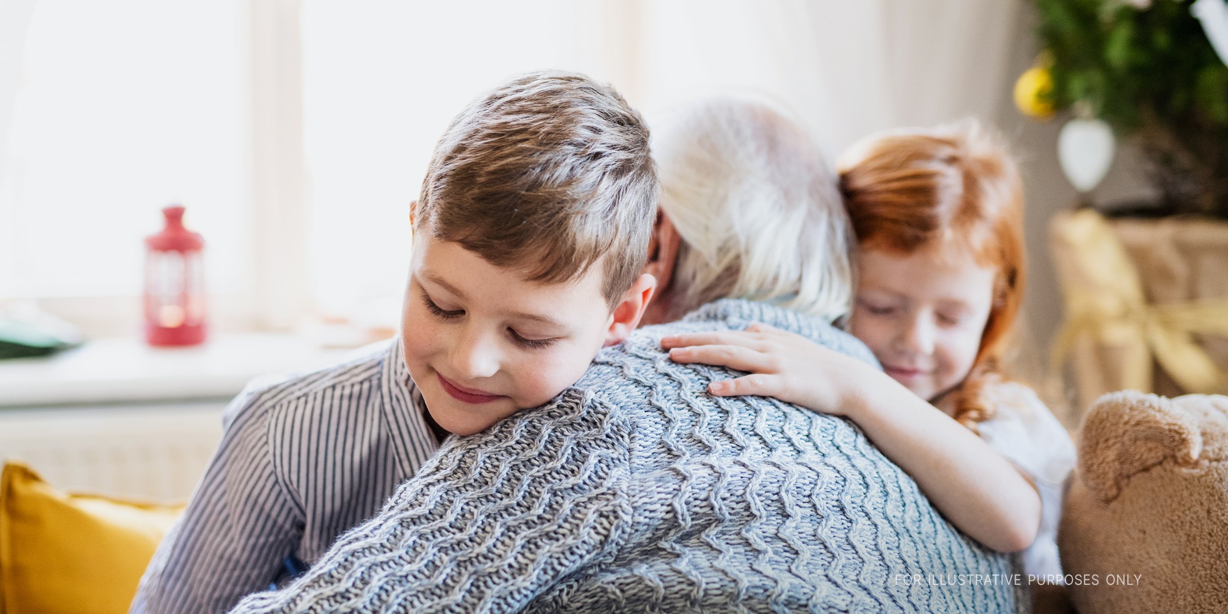 Children hugging an old man | Source: Shutterstock