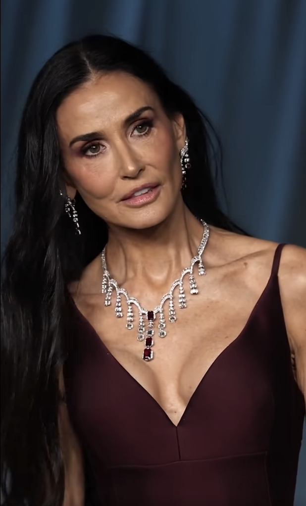 In a still, almost statuesque moment, Demi Moore looks on with a composed gaze, the dramatic angle of her collarbone and the shimmer of her necklace capturing the camera’s full attention in this sharp close-up. | Source: Facebook/TooFab
