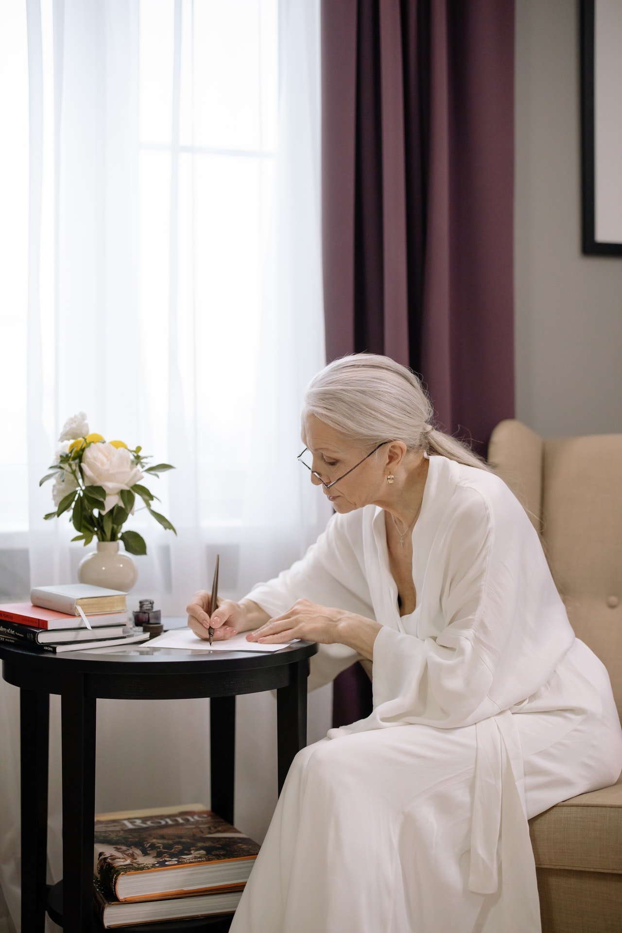 Una mujer mayor escribe una carta. | Foto: Pexels