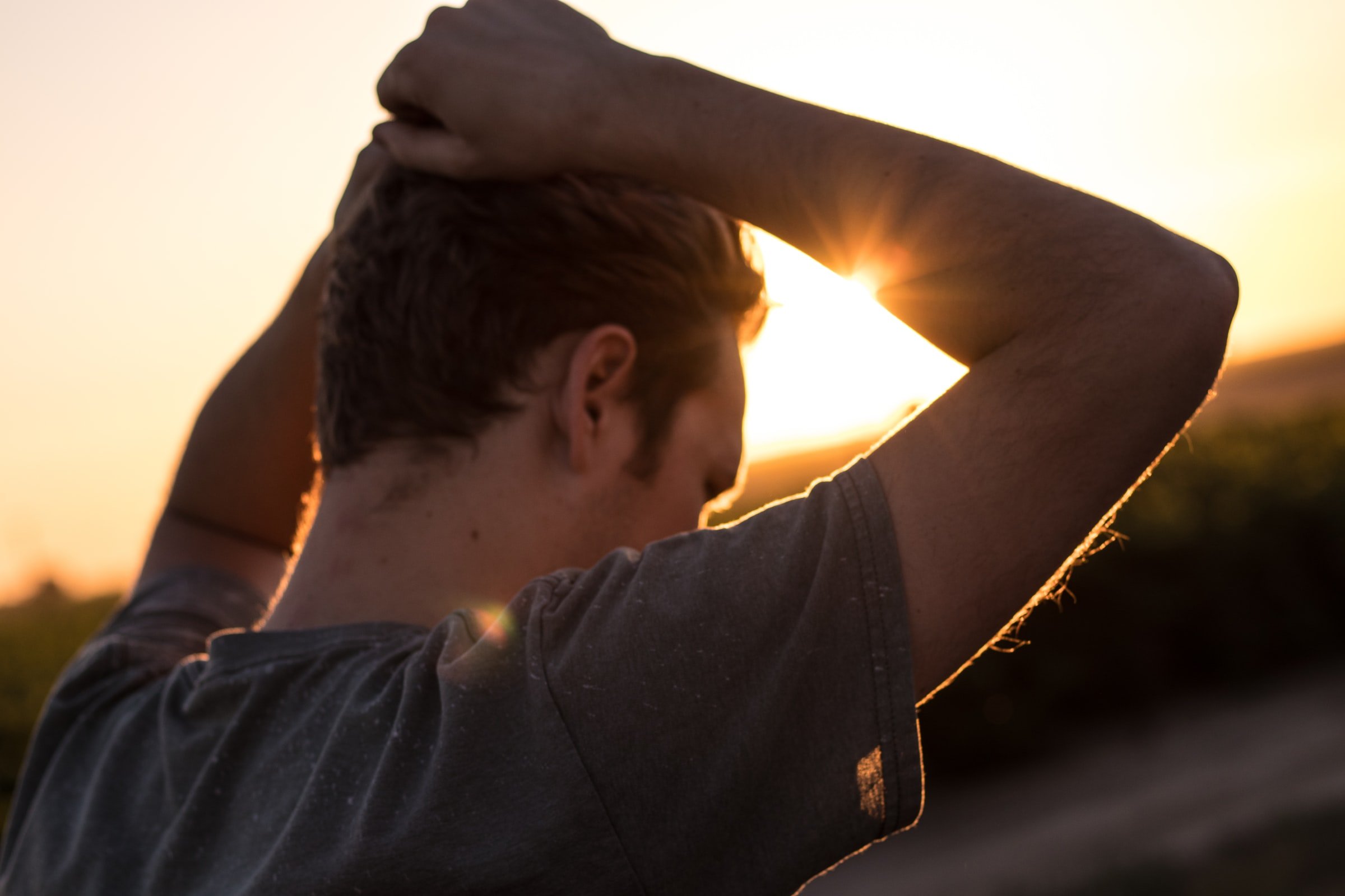 A man standing with his hands on his head. | Source: Unsplash