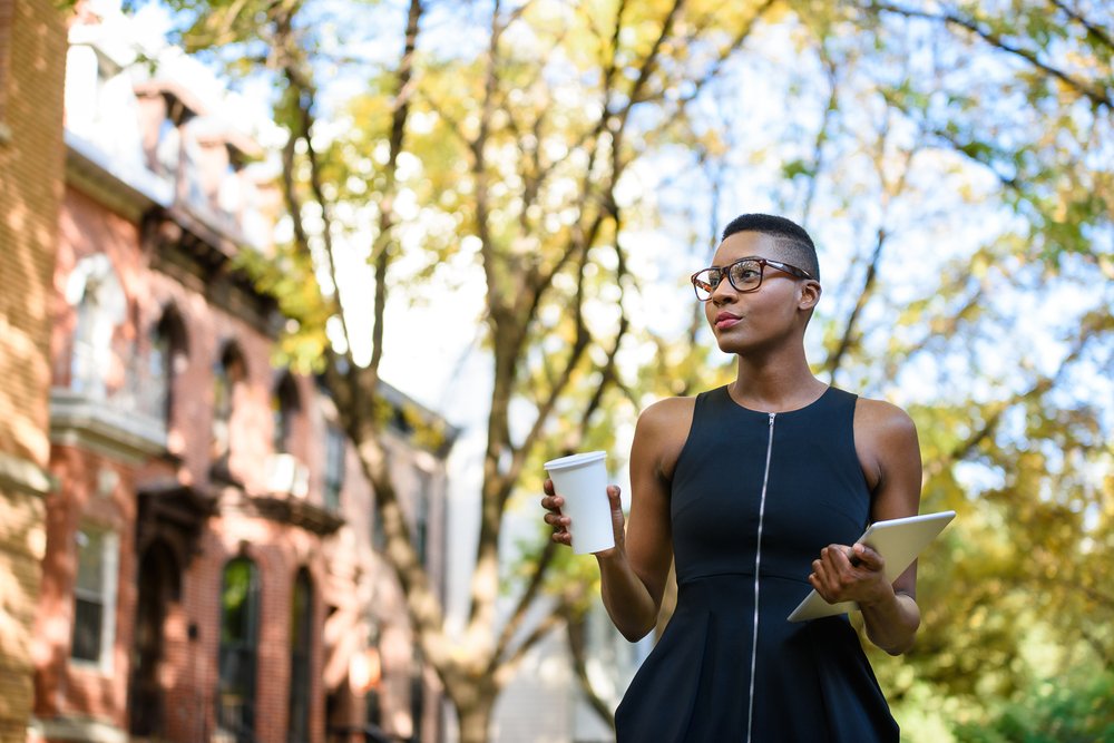 Joven empresaria caminando por la calle. | Fuente: Shutterstock