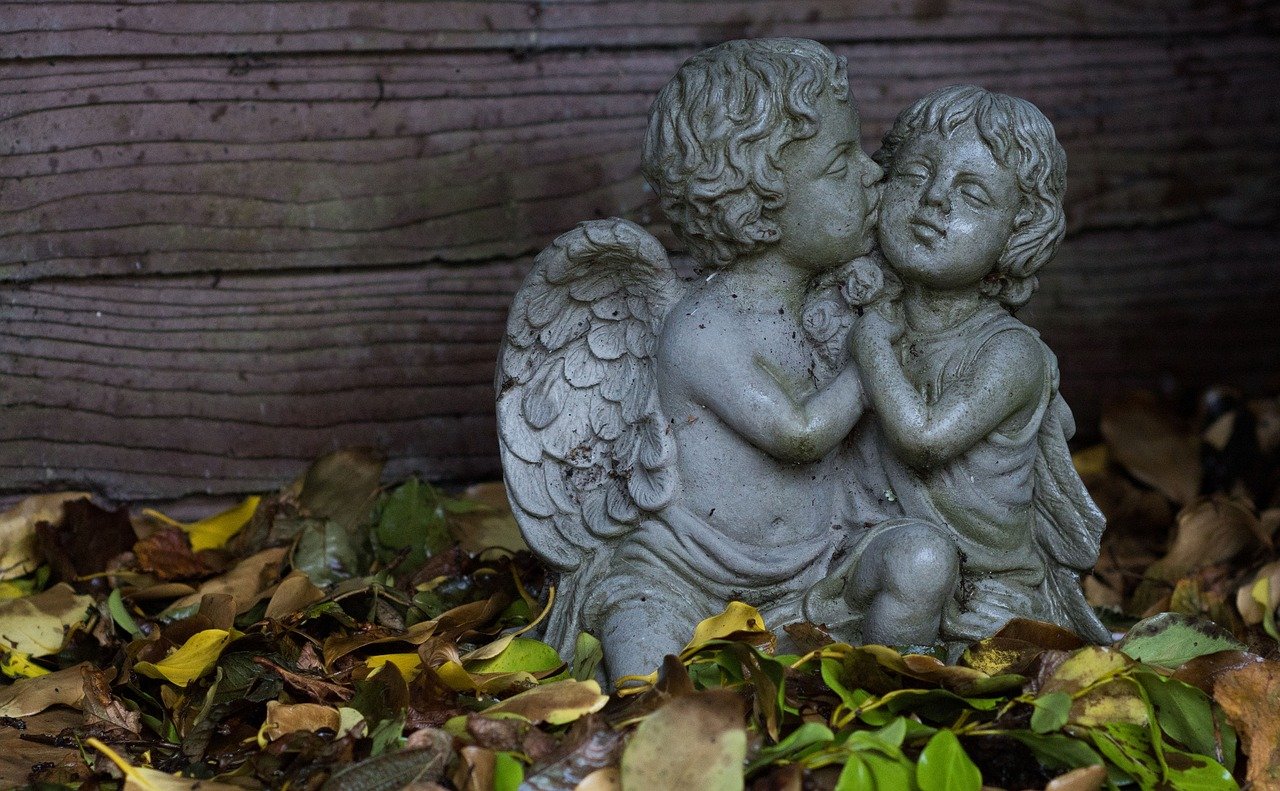 A statue of baby angels hugging in a garden | Photo: Needpix/Timelessbronze 