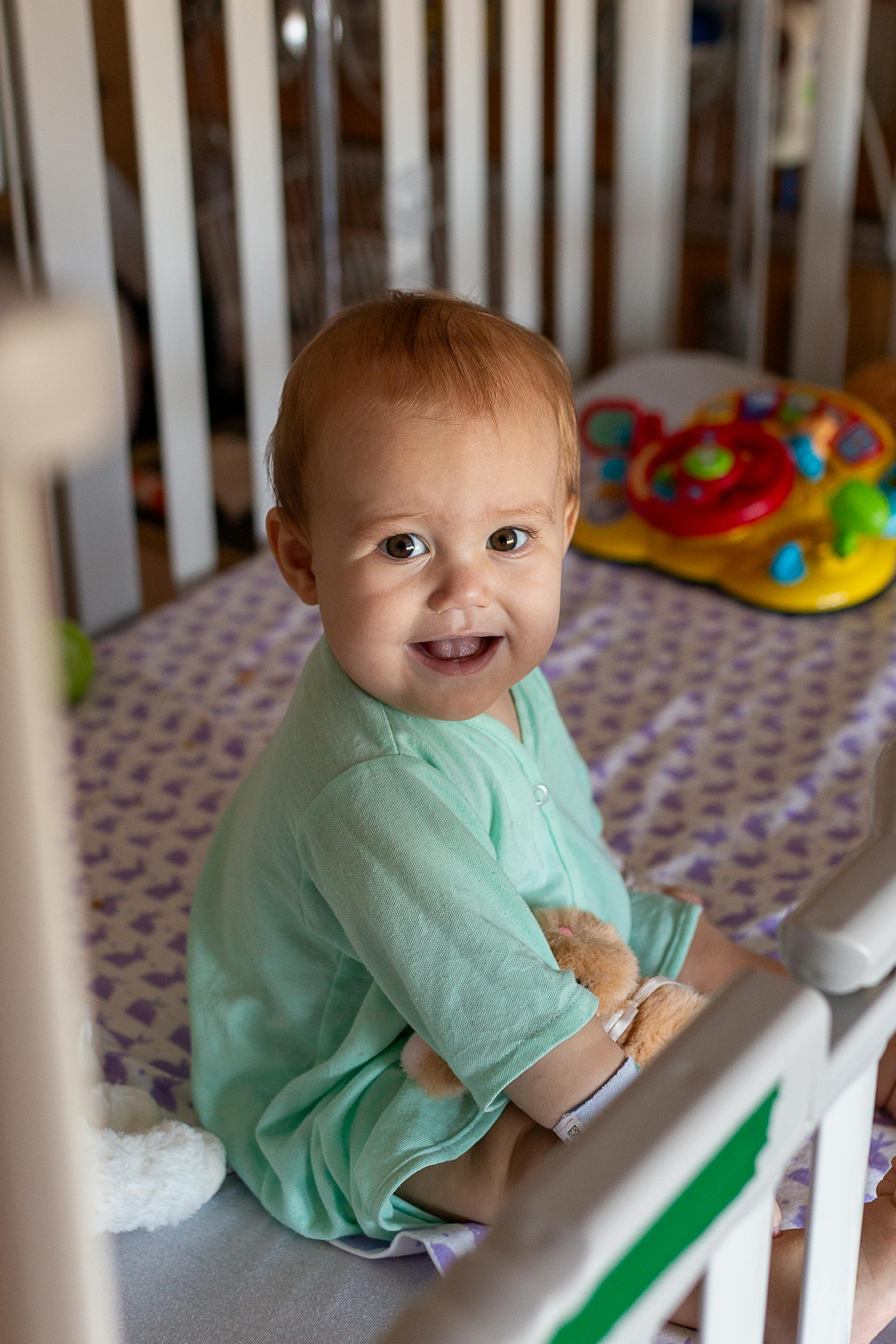A cute baby sitting in a crib | Source: Pexels