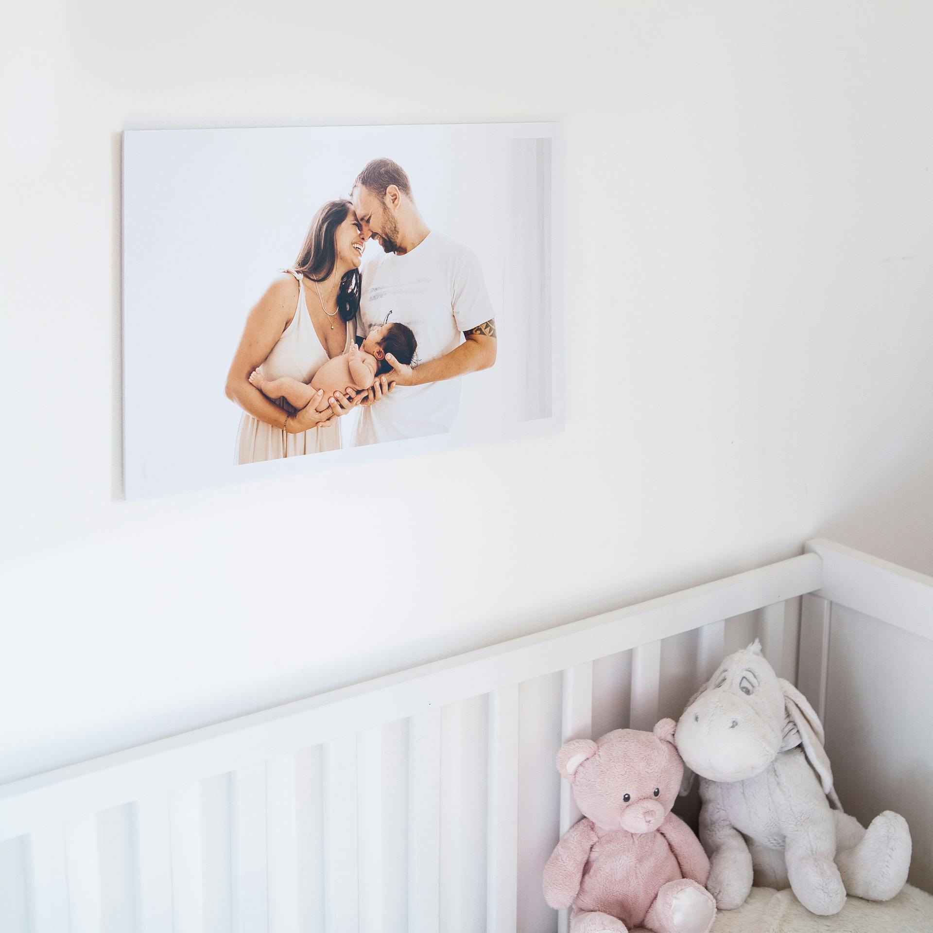 A photo of a couple with their newborn baby hanging in a room | Source: Pexels