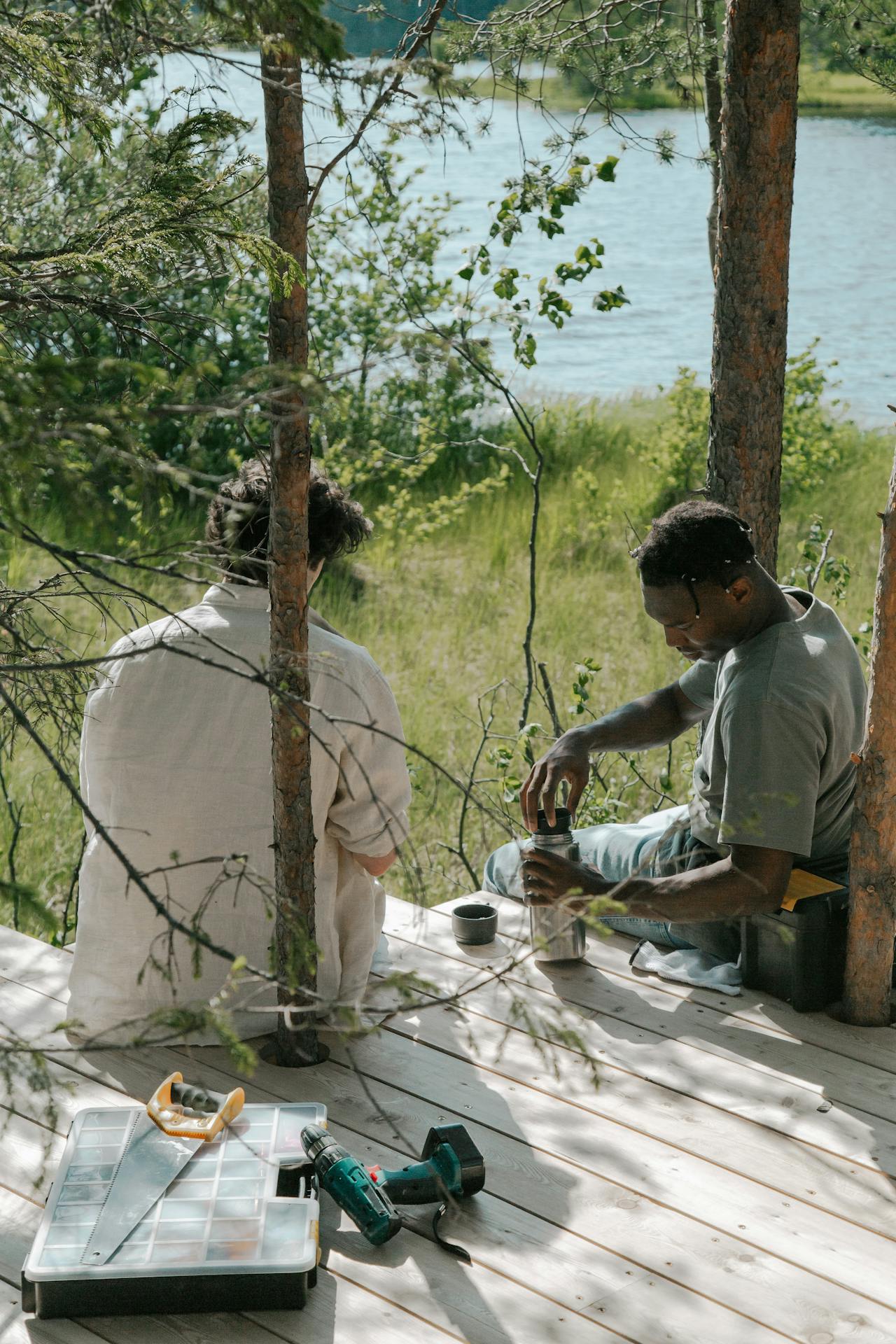 Two men sitting on wooden boards | Source: Pexels