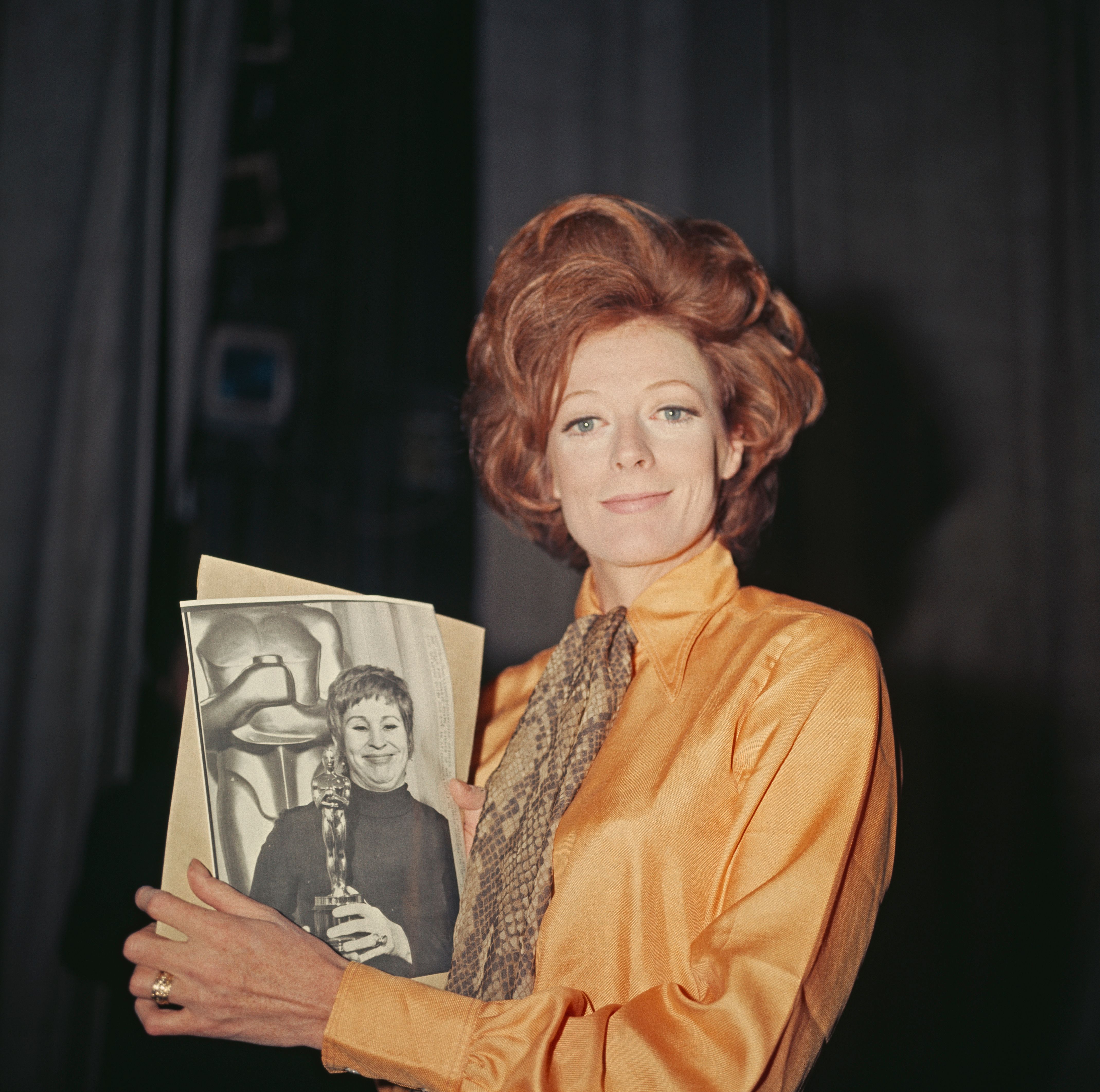 Maggie Smith holds a photo of American actress Alice Ghostley at the 42nd Academy Awards, at an Oscars party at the Old Vic Theatre in London on 10th April 1970. | Source: Getty Images