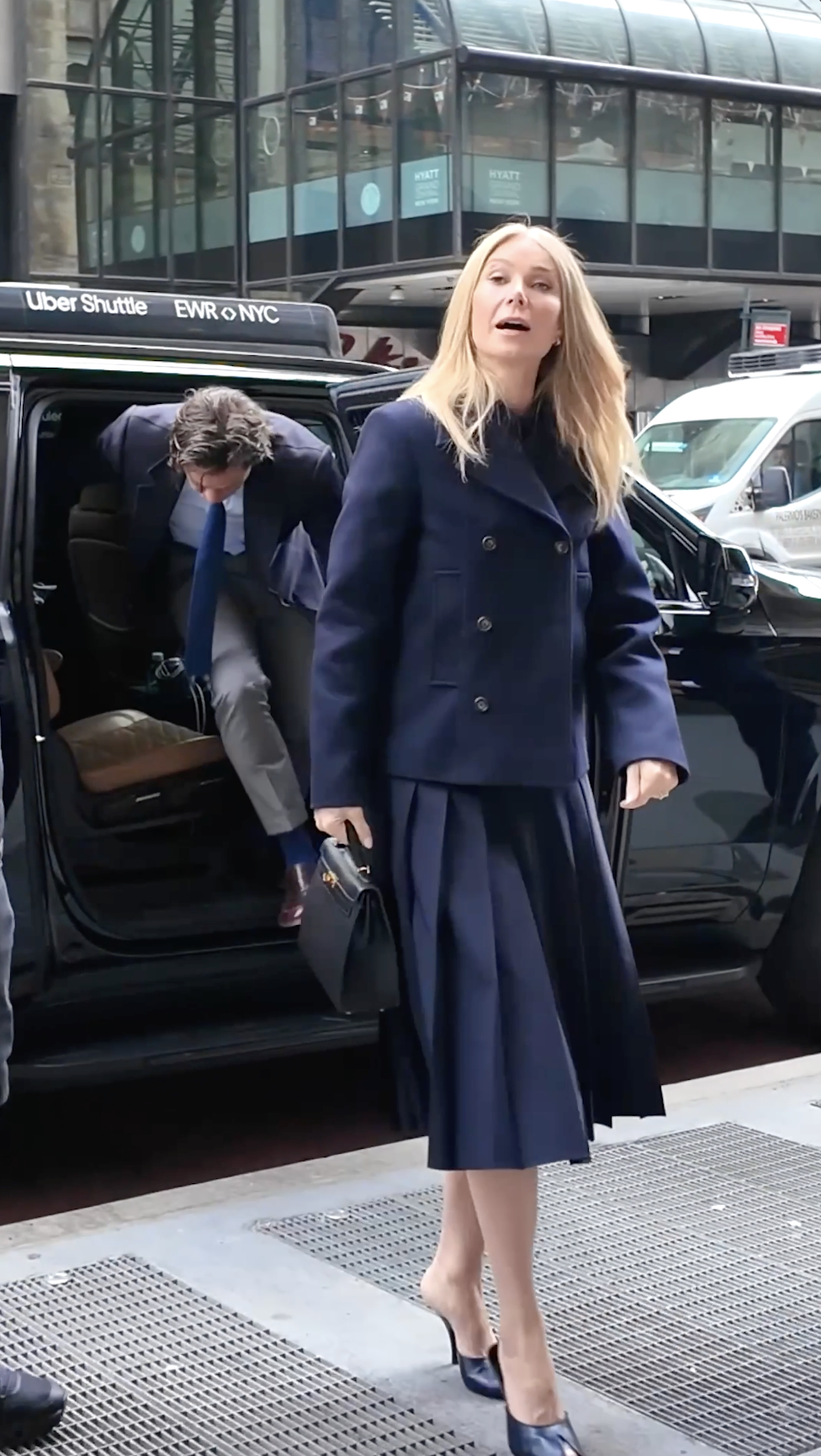 Gwyneth Paltrow looks ahead while walking on a New York sidewalk, her expression neutral as the clean lines of her tailored jacket remain in focus.