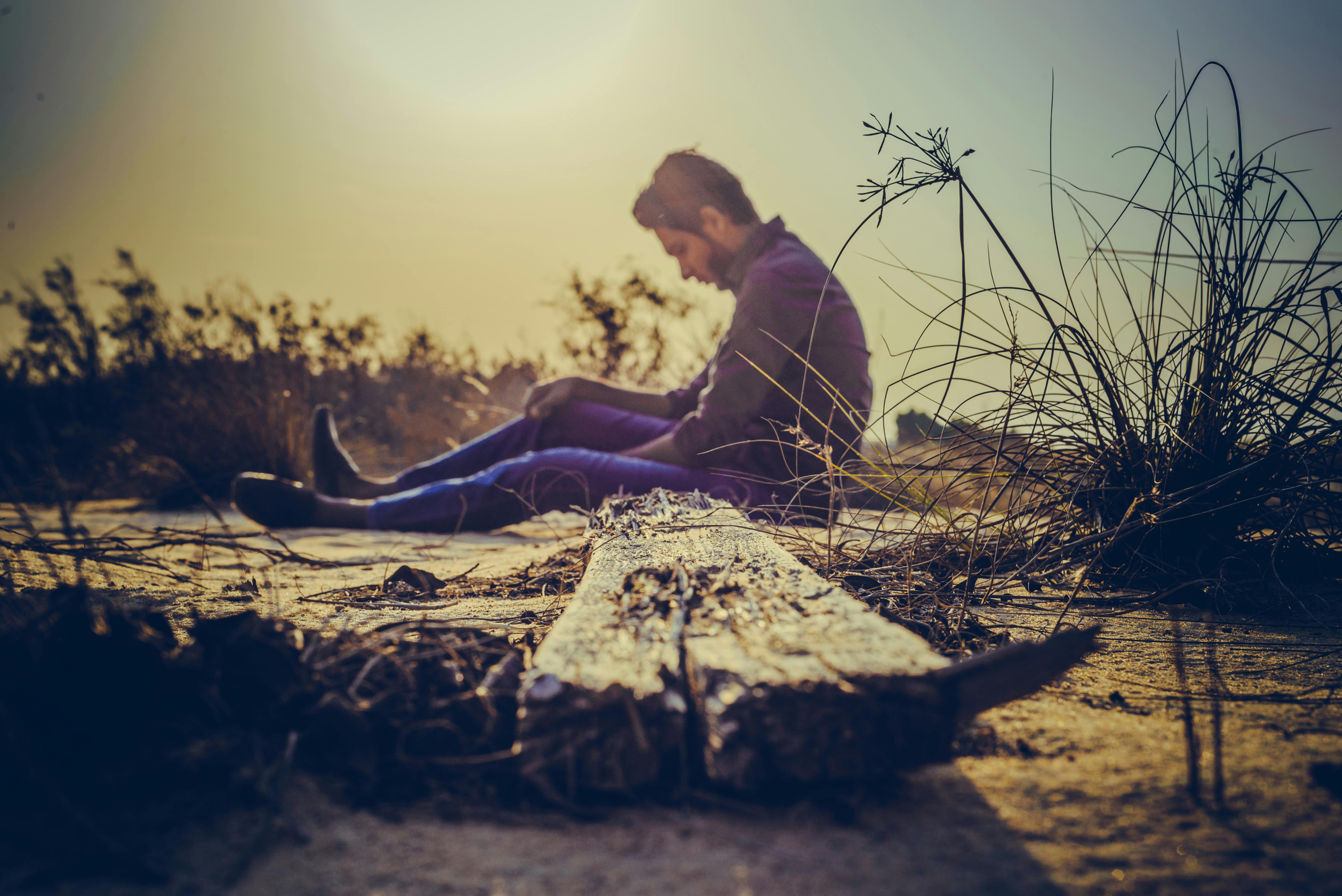 Sad man sitting on the side of the road | Source: Pexels