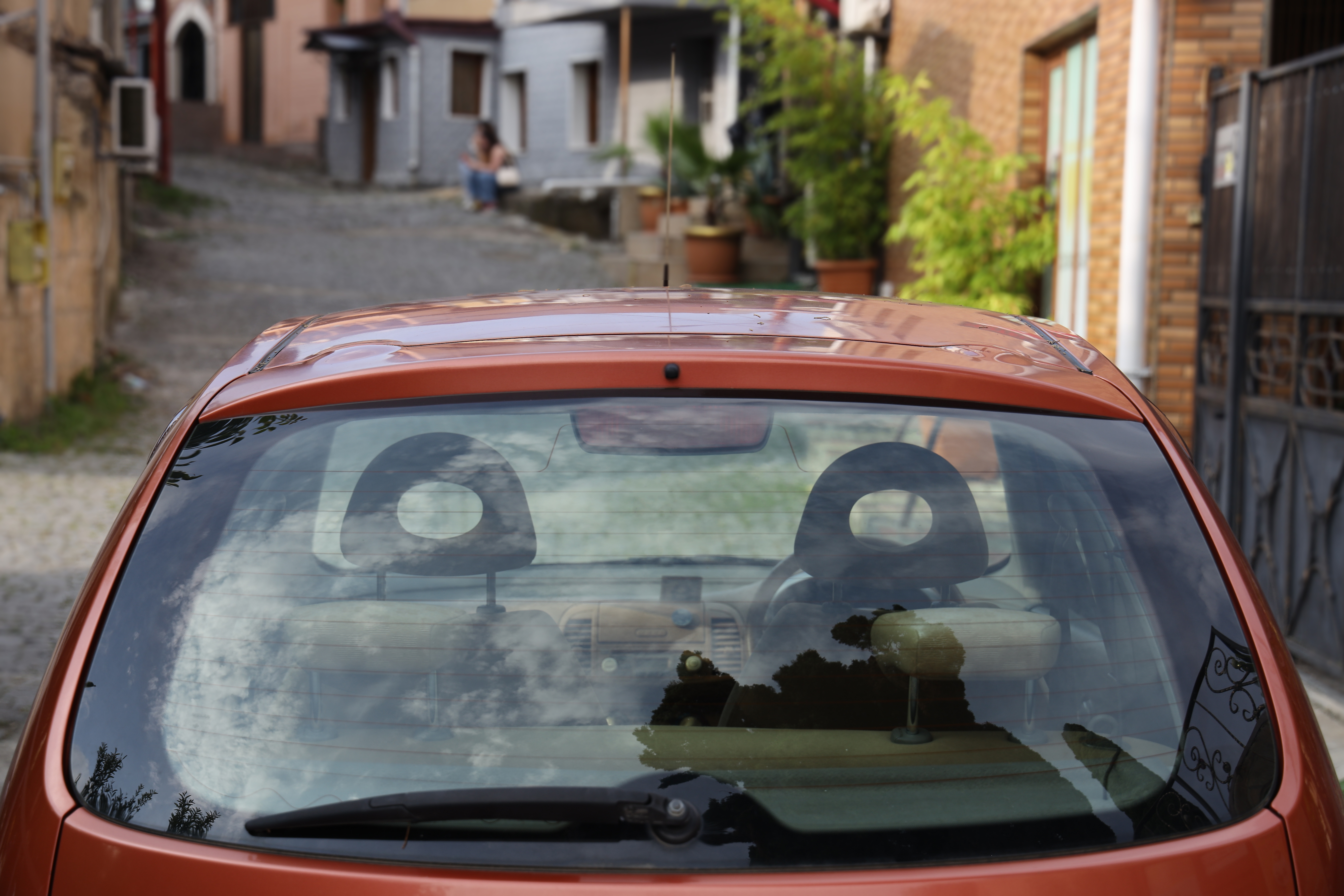 Back window of orange, brown car parked | Source: Shutterstock