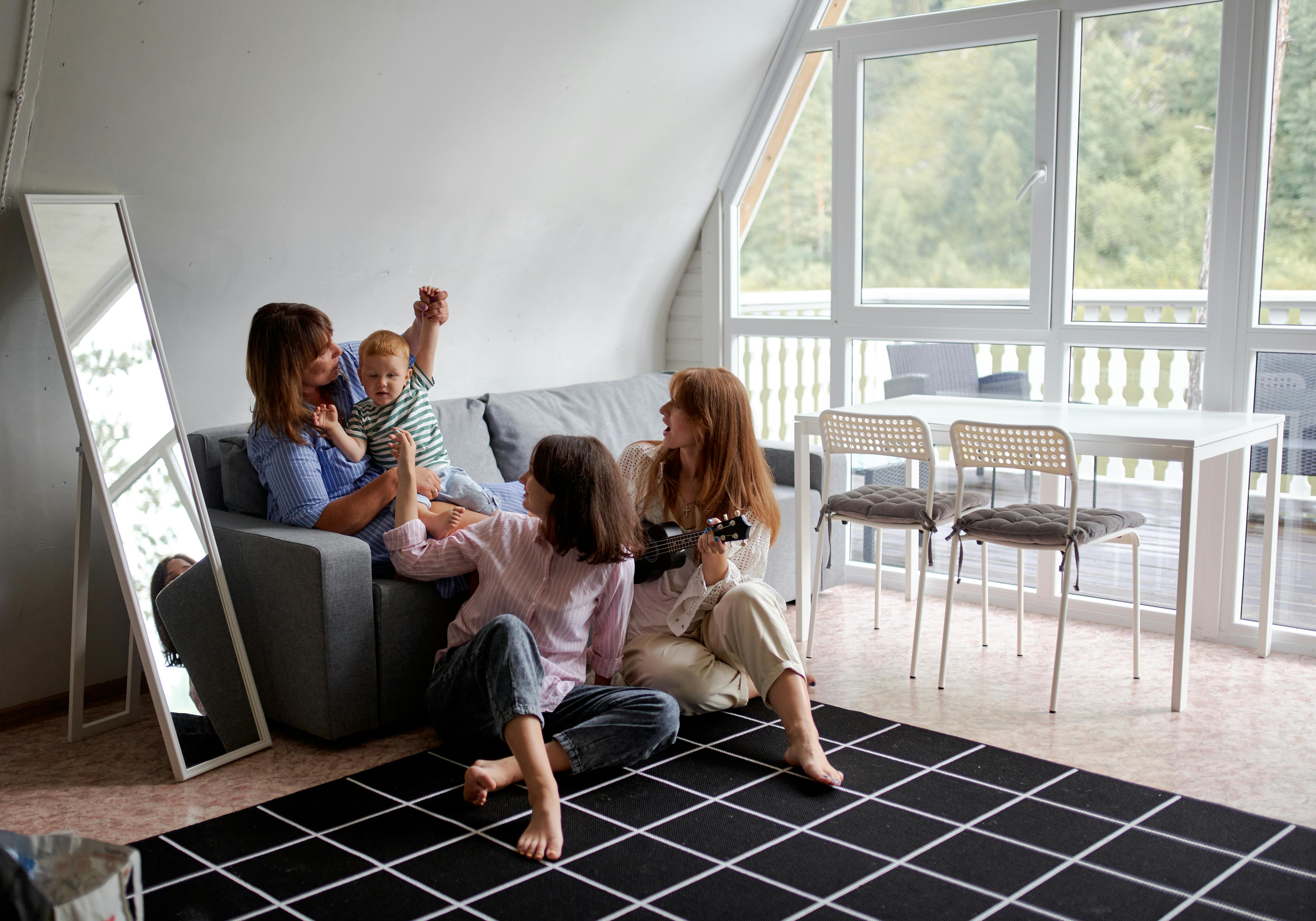 A happy family playing with a toddler | Source: Pexels