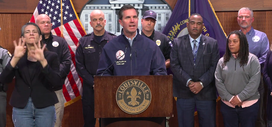 Kentucky Governor Andy Beshear providing updates on the tragic plane crash during an initial press conference involving authorities, posted on November 4, 2025. | Source: X/@LouMetroTV