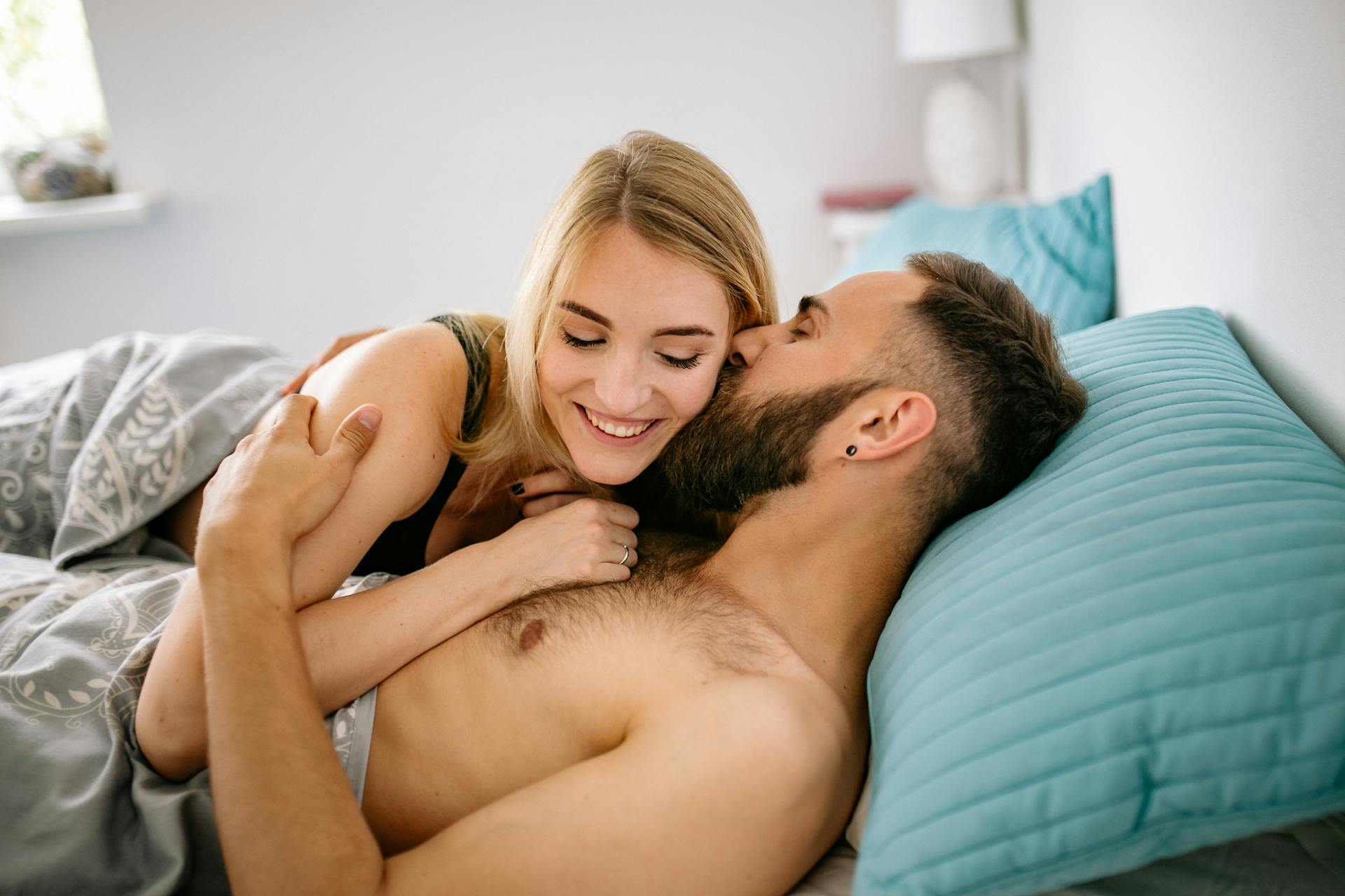 A man kissing a woman in bed | Source: Pexels