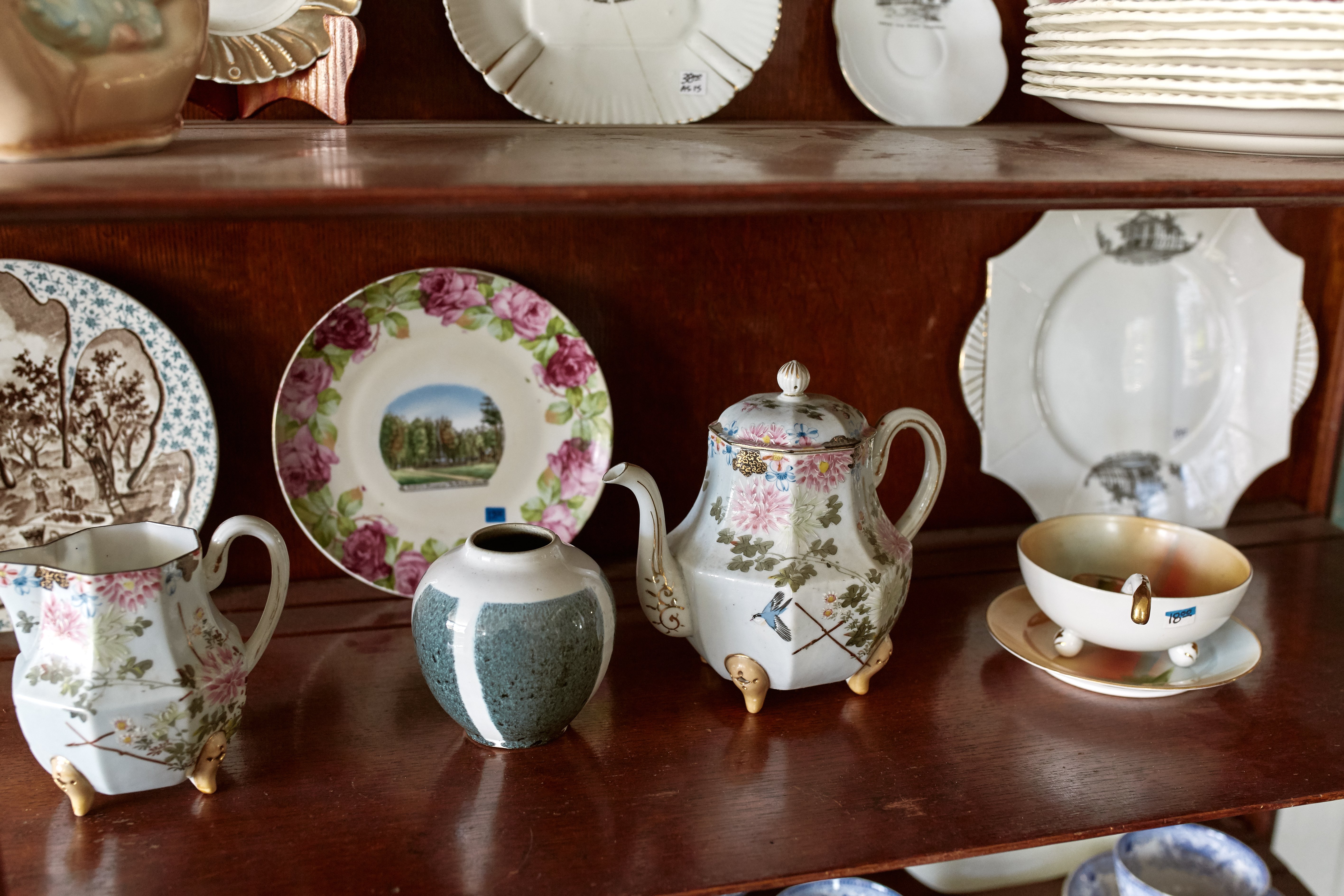 Vintage cabinet with decorative porcelain teapots for sale at a store. | Photo: Shtterstock
