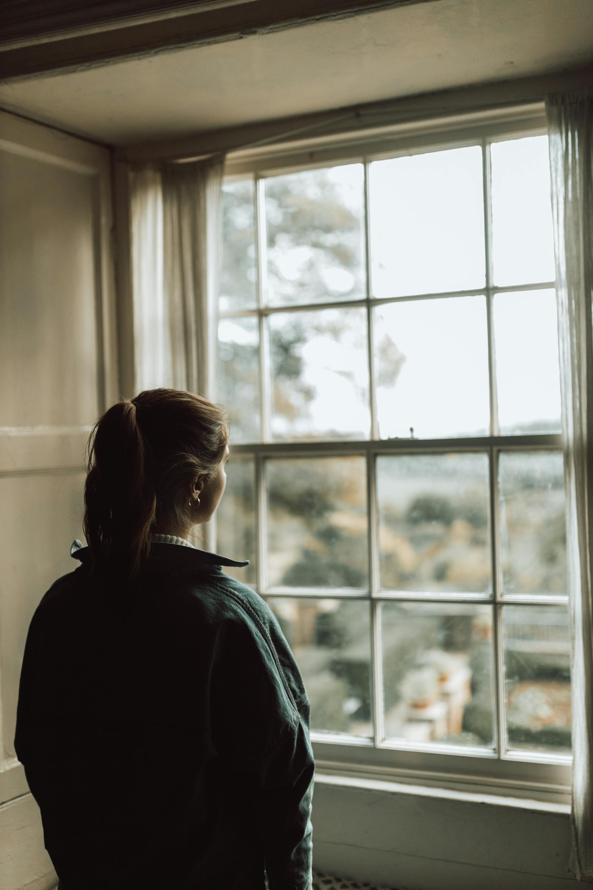 A woman looking out the window | Source: Pexels